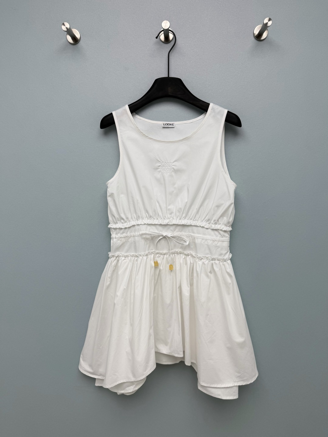 NO:822905,LOEW*26 new sleeveless waisted puffy dress, available in black and white, has both brand recognition and a girly feel. The iconic Anagram embroidery on the chest is the finishing touch, low-key yet recognizable, strengthening the brand texture. The yellow resin pendant on the waist drawstring is the brand's iconic detail design, adding a touch of agility and sophistication to the overall look. Sleeveless  The round neck design exposes the slender shoulder and neck lines, which is refreshing and elegant; the waist adopts a double-layer shirring + drawstring design, which can be freely adjusted to create a high waistline and optimize body proportions. The irregular hem A-line puff skirt has a girlish feel and can well modify the waist and hip lines. It is also friendly to the pear-shaped figure and has a sense of agility and elegance when walking ~ 2 colors and 3 codes SML  L, Loewe-clothing,loro piana,loewe,loewe,skirts,19860909LOEW*26新款无袖收腰蓬蓬连衣裙,黑白两色可选,兼具品牌辨识度与少女感,胸前的标志性Anagram刺绣是点睛之笔,低调又有辨识度,强化了品牌质感.腰部抽绳的黄色树脂坠饰,是品牌标志性的细节设计,为整体造型增添了一丝灵动与精致感.无袖圆领设计,露出纤细的肩颈线条,清爽又显气质；腰部采用双层抽褶+抽绳设计,可自由调节松紧,轻松打造高腰线,优化身材比例.不规则下摆A字蓬蓬裙摆,自带少女感,同时能很好地修饰腰臀线条,对梨形身材也很友好,走路时自带灵动飘逸感~2色3码SML L,罗意威-服装,loro piana,loewe,loewe,skirts,,Women's clothing
