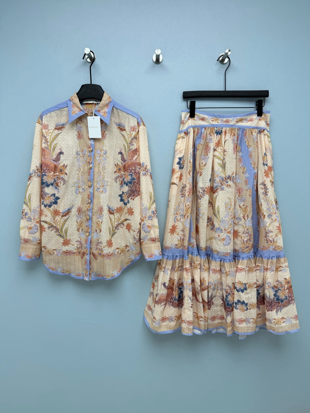 NO:822920,Zimmerman*/Zimmerman 26 new suit skirt, shirt and skirt combination  The base color is a gentle creamy apricot color, with low-saturated lavender blue trim, which neutralizes the complexity of large-area printing, and yellow leather can be easily controlled. The retro print printing of peacocks and flowers has an exotic holiday style, and because of the light tone processing, it is not exaggerated, and has the texture of 'wearing oil paintings on the body'. The shirt is a slightly loose long-sleeved version with dropped shoulders, with a pointed collar and  The buttons with pearl texture not only retain the neatness of the shirt, but also hide the flesh of the arms. The skirt is a high-waisted A-line cake skirt design. The waist and the blue trim of the skirt echo the shirt. The multi-layered ruffle skirt can perfectly modify the problem of hip width and thick legs, and it has a sense of elegance when walking. This apricot + lavender blue printed suit directly welds the tenderness of spring to the body!  Single color code 4 SMLXLB, Hermès-clothing, hermes, skirts, shirts,19860909Zimmerman*兹/默曼 26新款套装裙 衬衣半裙的组合 底色是温柔的奶油杏色,搭配低饱和的薰衣草蓝镶边,中和了大面积印花的繁杂感,黄皮也能轻松驾驭.孔雀与花卉的复古版画印花,自带异域度假风情,又因浅色调处理不显浮夸,自带“把油画穿在身上”的质感.衬衫是微宽松的落肩长袖版型,搭配尖领与珍珠质感纽扣,既保留了衬衫的利落感,又能藏住手臂拜拜肉.半裙是高腰A字蛋糕裙设计,腰部与裙摆的蓝色镶边和衬衫呼应,多层荷叶边裙摆能完美修饰胯宽、腿粗问题,走路时自带飘逸感.这套杏色+薰衣草蓝的印花套装,直接把春日的温柔焊在身上了！单色4码SMLXLB,爱马仕-服装,hermes,skirts,shirts,,Women's clothing