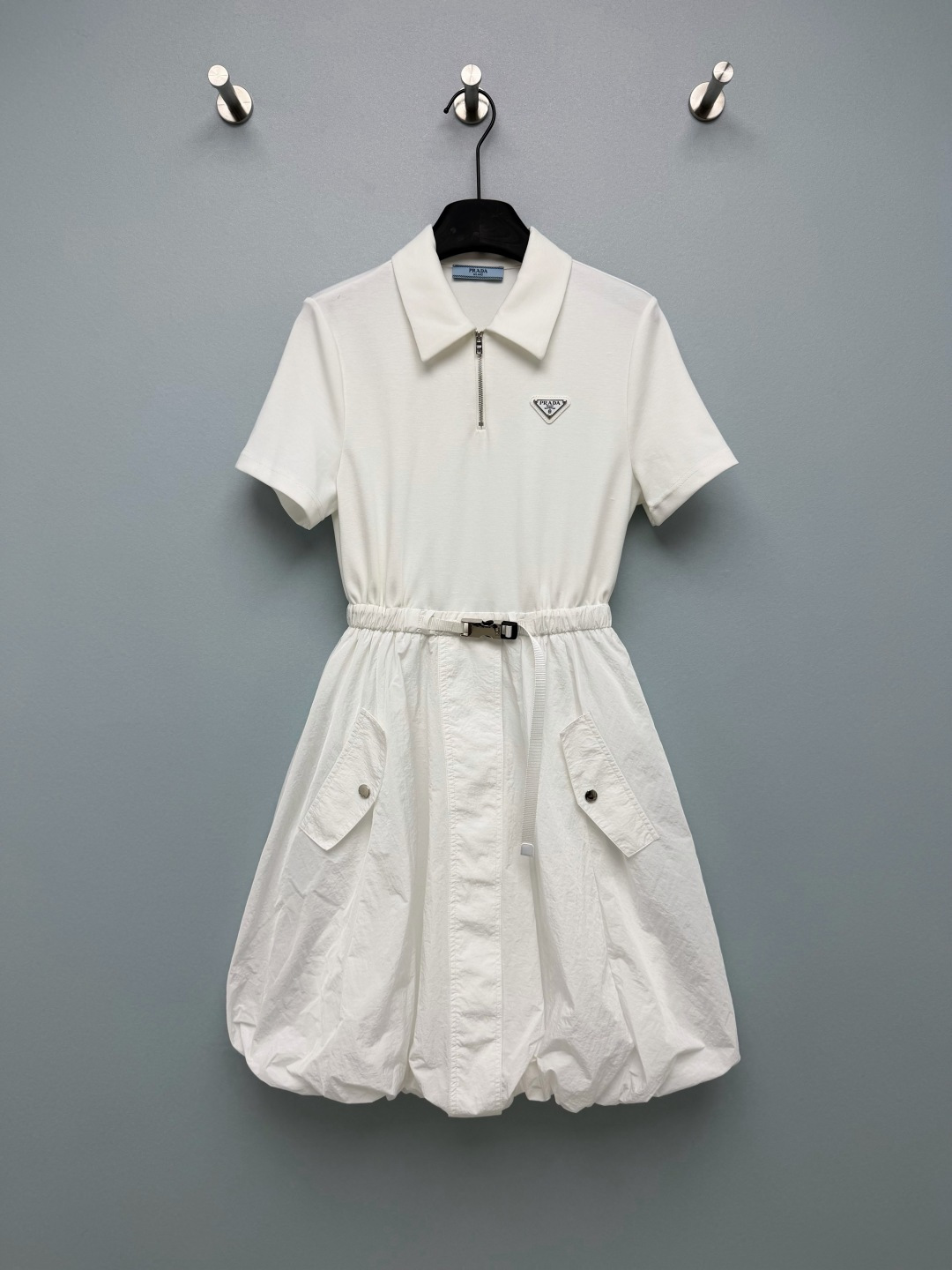 NO:825607,Prad*26 new lapel spliced flower bud dress Polo collar short sleeves + waisted flower bud skirt splicing design  The upper part is made of soft and skin-friendly knitted fabric, and the lower part is made of crisp and stylish nylon fabric. The splicing design combines comfort and style. It comes with a lining to avoid exposure. It is available in black and white, white is refreshing and clean with a sense of first love, and black has a cool and cool feeling. The iconic triangle logo on the chest is embellished, low-key and brand-recognizable. The belt buckle design adds workwear-style details. This dress is the perfect choice for sweet and cool spring and summer outfits.  2 colors and 3 codes SMLX, Prada-clothing, prada, prada, skirts, T-shirt,19860909Prad*26新款翻领拼接花苞连衣裙 Polo领短袖+收腰花苞裙摆的拼接设计 上身为柔软亲肤的针织面料,下身为挺括有型的尼龙面料,拼接设计兼具舒适感与造型感；自带内衬,避免走光.黑白两色可选,白色清爽干净自带初恋感,黑色自带清冷酷飒感；胸前标志性三角标点缀,低调又有品牌辨识度；腰带扣设计增添工装风细节.春夏甜酷穿搭被这条连衣裙承包了 2色3码SMLX,普拉达-服装,prada,prada,skirts,T-shirt,,Women's clothing