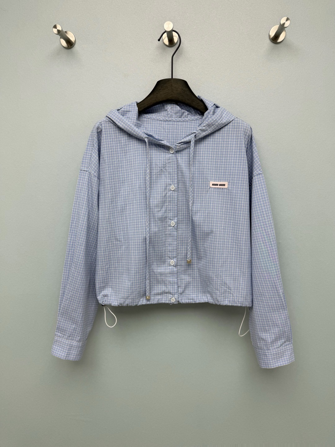 NO:825636,miumi*26 new plaid hooded short jacket  The college-style plaid hooded short jacket has a fresh and sweet girly atmosphere. It is the popular 'miu style' and 'campus style' must-have item, and it can easily be girly. The short style + loose shoulder cut, with a drawstring design at the hem, are made of light and breathable plaid fabric, and the iconic logo woven label on the chest is embellished, which is low-key and brand-recognizable; the hood + drawstring design adds a sense of leisure and practicality. I am already looking forward to the days when I wear it with white shoes to go out!  2 colors and 3 sizes SMLR, Miu Miu-clothing, miumiu, jackets & coats, hats,19860909miumi*26新款格纹连帽短款外套 学院感格纹连帽短款外套,自带清新甜妹氛围,是当下热门的“miu系穿搭”“校园风”刚需单品,轻松拿捏少女感.短款+宽松落肩剪裁,搭配下摆抽绳设计,采用轻薄透气的格纹面料,胸前标志性logo织标点缀,低调又有品牌辨识度；连帽+抽绳设计,增添休闲感与实用性.已经开始期待穿它配小白鞋出门的日子了！2色3码SMLR,缪缪-服装,miumiu,jackets & coats,hats,,Women's clothing