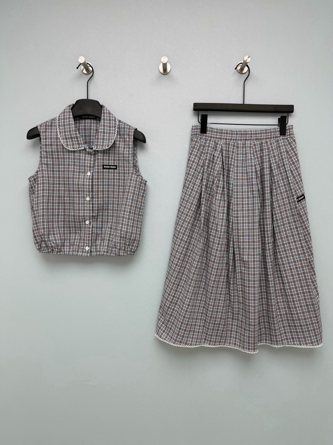 NO:828086,miu mi*26 new plaid doll collar suit combination of doll collar sleeveless vest + high waist A-line skirt  The doll collar modifies the face and has an age-reducing effect; the sleeveless vest is neat and slimming, and paired with a high-waisted skirt, it can easily raise the waistline. The miu woven label on the chest of the vest and the side of the skirt is the soul highlight of the whole set, which is low-key and has its own brand recognition; the white lace on the neckline and skirt adds a girly feel and has a retro college temperament. The classic brown plaid comes with a retro filter! 单色3码SML,缪缪-服装,miumiu,skirts,19860909miu mi*26新款格纹娃娃领套装 娃娃领无袖马甲+高腰A字半裙的组合 娃娃领修饰脸型,自带减龄效果；无袖马甲利落显瘦,搭配高腰半裙,轻松拉高腰线,马甲胸口和半裙侧边的miu织唛标,是整套的灵魂亮点,低调又自带品牌辨识度；领口和裙摆的白色蕾丝花边,增添了少女感,自带复古学院气质.经典的棕调格纹,自带复古滤镜！单色3码SML,缪缪-服装,miumiu,skirts,,Women's clothing