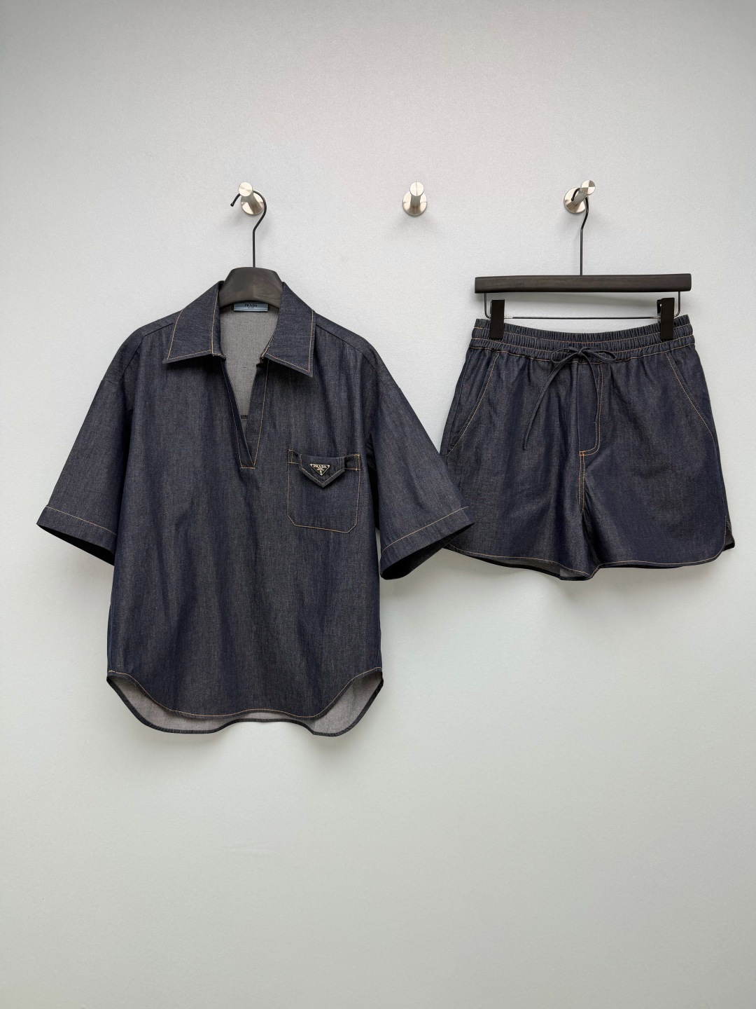 NO:829538,Prad*26 new denim casual suit  The triangular metal logo on the top pocket and the back pocket of the shorts is the core of brand recognition. It is low-key and full of high-end, and the details are ecstatic. The top is a V-neck semi-cardigan short-sleeved shirt with dropped shoulders and a loose cut, which has a sense of relaxation; the shorts have an elastic waist drawstring design, which does not pick up the waistline, and can easily hide the flesh for a pear-shaped figure. The dark indigo denim fabric is paired with topstitching to restore the classic denim texture. The overall color matching is refreshing and attractive, with a high-end casual style.  The whole set is a no-brainer to match, and it is not exaggerated for daily wear. It is low-key and elegant. Monochrome size 3 SML, Prada-clothing, prada, prada, shorts, shirts, T-shirt,19860909Prad*26新款牛仔休闲套装 上衣口袋和短裤后袋的三角金属标,是品牌辨识度的核心,低调又充满高级感,细节控狂喜.上衣是V领半开襟短袖衬衫,落肩+宽松剪裁,自带松弛感；短裤是松紧腰抽绳设计,不挑腰围,梨形身材也能轻松藏肉.深靛蓝牛仔面料搭配明线车缝,还原经典丹宁质感,整体配色清爽耐看,自带高级休闲风 整套搭配不用费脑,日常穿也完全不夸张,低调又贵气 单色3码 SML,普拉达-服装,prada,prada,shorts,shirts,T-shirt,,Women's clothing