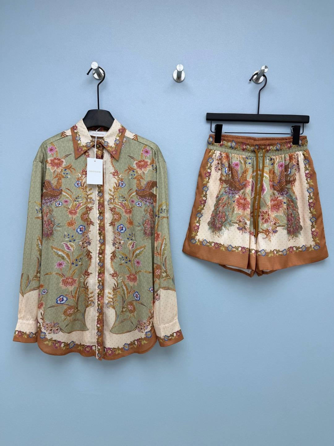 NO:830918,ZIMMERMAN*26 new retro flower and bird print shirt + shorts set, simulated silk fabric version with soft luster  The design is based on the retro peacock flower print. The beige/green background is paired with pink and blue contrasting flowers, with polka dots and plaid details. It is full of exotic palace style and has a noble atmosphere. It looks white and noble. The top is in a loose lapel shirt style, which hides the flesh and makes you look slimmer.  , the contrasting color binding and printed splicing on the placket and cuffs are full of details, and they look good when worn alone. The shorts have a high-waisted elastic waist + drawstring design for maximum comfort. The pants body continues the same print, and the loose fit modifies the leg shape, and can be easily controlled by a pear-shaped figure.  The whole set is full of atmosphere, and it doesn’t go against the grain when paired with other clothes alone. The utilization rate is super high. It’s really suitable for spring and summer!  2 colors and 4 codes SMLXLB, Zimmerman-clothing, shorts, shirts, real silk,19860909ZIMMERMAN*26新款复古花鸟印花衬衫+短裤套装 仿真丝面料版本 自带柔和光泽感 以复古孔雀花卉印花为核心设计,米色/绿色底色搭配粉蓝撞色花卉,搭配波点与格纹细节,充满异域宫廷风情,自带贵气氛围感.显白又显贵.上衣宽松翻领衬衫版型,藏肉显瘦一绝,门襟、袖口的撞色包边和印花拼接,细节感拉满,单穿内搭都好看.短裤高腰松紧腰+抽绳设计,舒适度直接拉满,裤身延续同款印花,宽松版型修饰腿型,梨形身材也能轻松驾驭. 整套穿氛围感拉满,单拆搭配其他衣物也完全不违和,利用率超高.春夏穿真的太合适了！ 2色4码SMLXLB,兹默曼-服装,shorts,shirts,real silk,,Women's clothing
