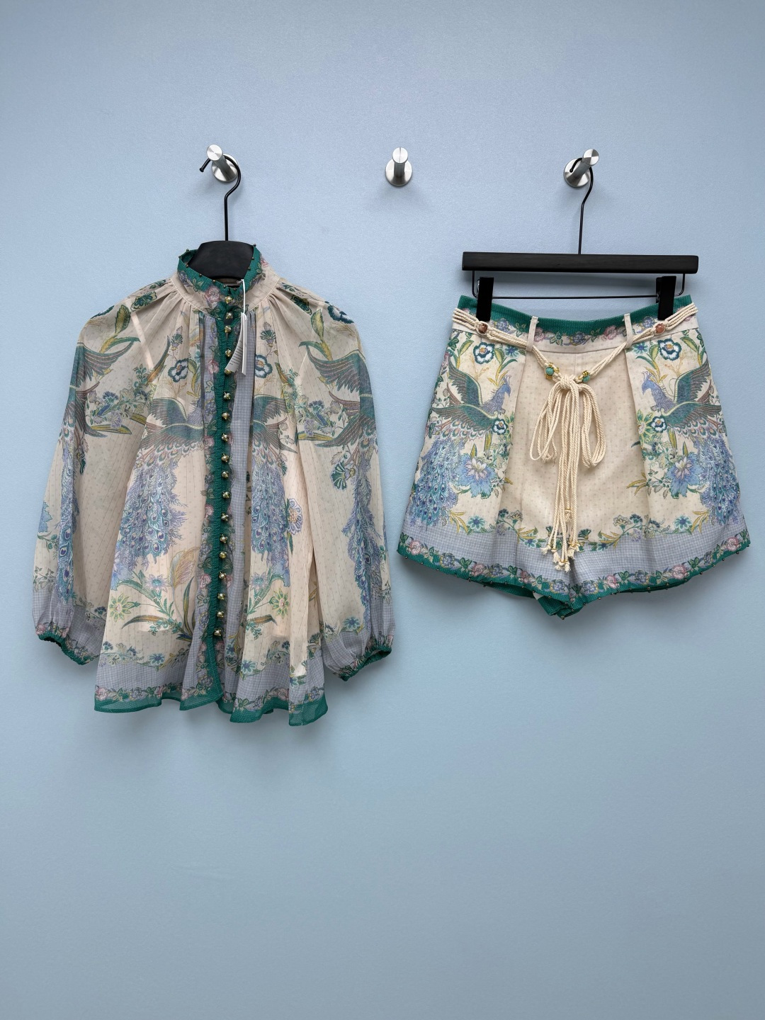 NO:830925,Zimmerma*26 new peacock print vacation set  It uses a retro peacock positioning print, with apricot background and contrasting colors of peacock blue, dark green, and soft pink. It has an oil painting texture. The peacock feather texture is clear and floral patterns embellish it, giving it an exotic vacation atmosphere. The combination of apricot background and peacock blue print is gentle and white, and you can instantly transform into an exotic girl in an oil painting when you put it on~  The top has semi-transparent lantern sleeves, and the slightly transparent fabric has a hazy atmosphere. The enamel buttons on the placket are full of details, and the dark green binding neutralizes the sweet feeling. The high-waisted shorts come with a turquoise drawstring, and the A-line shape makes the waist-to-hip ratio perfect. The fabric is breathable and comfortable, and it is perfect for beach vacations and store visits!  Wear it directly to unlock the effortless sense of relaxation, and take great photos. Monochrome 4-code SMLXLB, Zimmerman-clothing, shorts,19860909Zimmerma*26新款孔雀印花度假套装 采用复古孔雀定位印花,搭配奶杏底色与孔雀蓝、墨绿、柔粉撞色,自带油画质感,孔雀羽毛纹理清晰,花卉纹样点缀,自带异域度假氛围.奶杏底色+孔雀蓝印花的搭配,温柔又显白,穿上秒变油画里的异域少女~上衣是半透灯笼袖,微透的面料自带朦胧氛围感,门襟的珐琅彩纽扣细节感拉满,墨绿包边又中和了甜腻感.高腰短裤自带绿松石抽绳,A字版型把腰臀比修饰得绝绝子,面料透气又舒服,海边度假、探店穿都超合适！ 穿上直接解锁不费力的松弛感,拍照巨出片 单色4码SMLXLB,兹默曼-服装,shorts,,Women's clothing