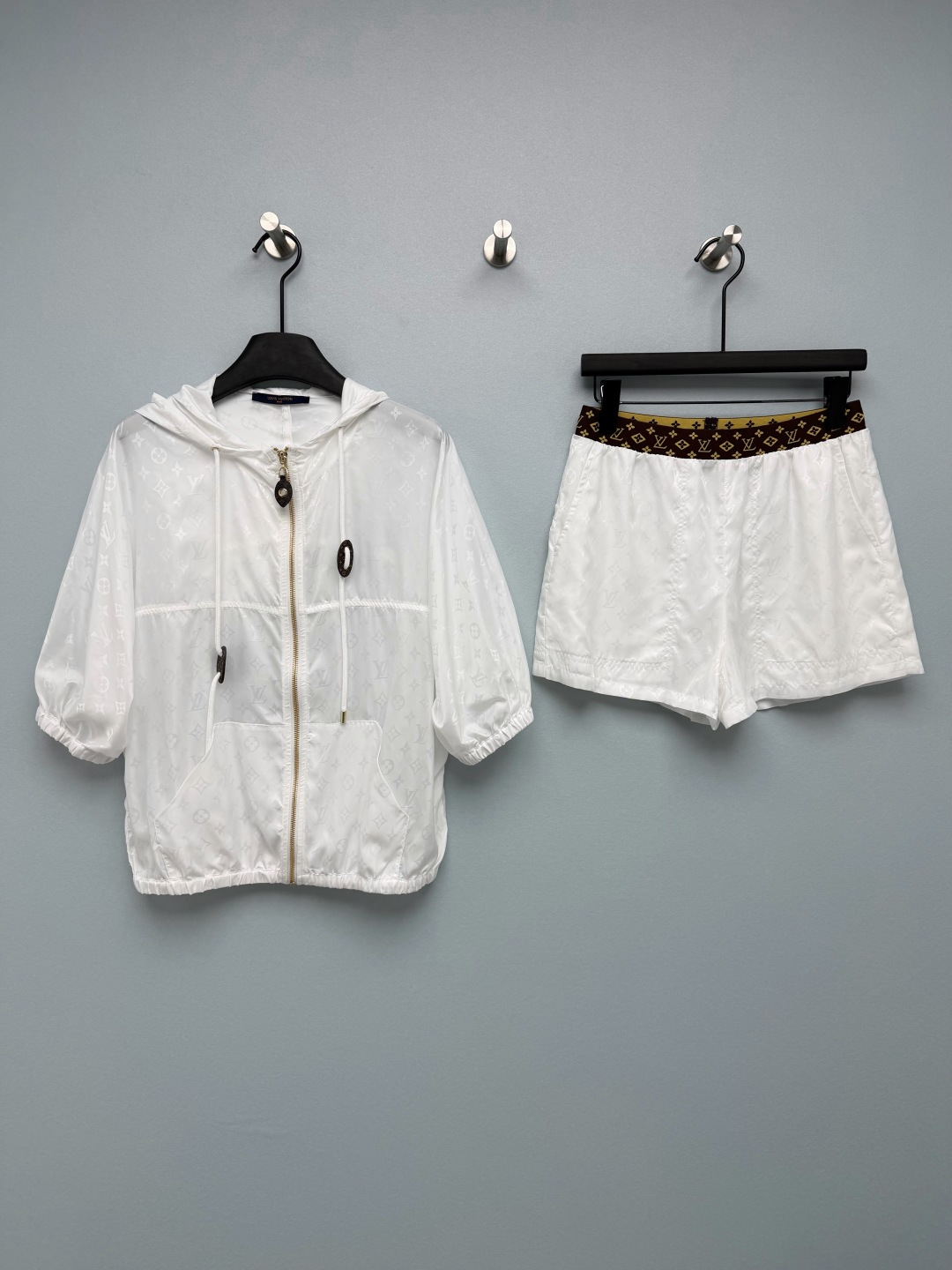 NO:855324,Louis Vuitto*26 new all-print hooded shorts suit, a combination of hooded short jacket + shorts from the same series. The hood is removable and made of light nylon fabric.  The fabric is light and breathable, so it is not stuffy to wear in summer. The classic Monogram is integrated into the fabric texture, showing a delicate luster under the light, which not only retains brand recognition but avoids exaggeration. The jacket is a short hooded design, with raglan sleeves + elastic cuffs/hem, and a front zipper closure; the shorts are a high-waisted A-line version, with a presbyopic waistband, elastic waistband + side zipper pockets, and the length is in the middle of the thigh, visually elongating the proportions of the legs. Who can resist a fairy suit that you don’t have to think about matching when going out?  The black model is cool and slimming, while the white model is clean and refreshing. I want to wear both colors!  2 colors 3 codes SML,Louis Vuitton-clothing,louis vuitton,louis vuitton,shorts,jackets & coats,hats,19860909Louis Vuitto*26新款满印连帽短裤套装 连帽短款外套+同系列短裤的组合 帽子可拆卸 采用轻薄尼龙面料 面料轻薄透气,夏天穿也不闷,经典Monogram融入面料肌理,在光线下呈现细腻光泽感,既保留品牌辨识度又避免浮夸.外套为短款连帽设计,插肩袖+松紧袖口/下摆,前襟拉链开合；短裤为高腰A字版型,搭配老花腰头 松紧腰头+侧拉链口袋,长度在大腿中部,视觉上拉长腿部比例.谁能拒绝一套出门不用想搭配的神仙套装啊！黑色款酷飒又显瘦,白色款干净又清爽,两种颜色都想all in！2色3码SML,路易威登-服装,louis vuitton,louis vuitton,shorts,jackets & coats,hats,,Women's clothing