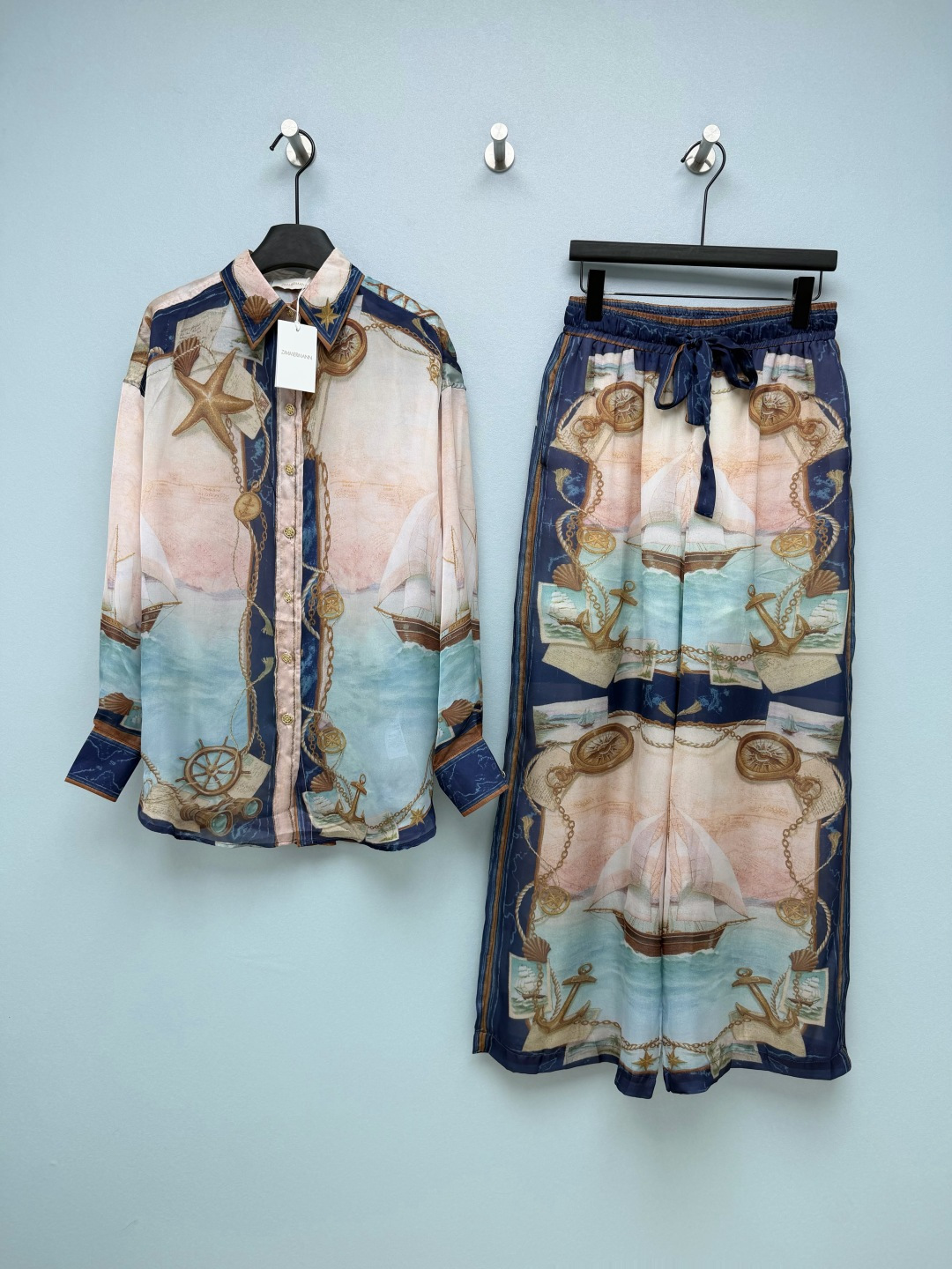 NO:856082,Zimmerma**26 new nautical style print suit  Inspired by retro nautical maps, sailboats, anchors, compasses, starfish and other elements are presented with the texture of oil paintings. It is paired with a blue-pink gradient ocean background, giving it a retro and romantic nautical atmosphere. The color is gentle and high-end, and yellow leather can be easily controlled. The lapel + single-breasted design has a loose silhouette that is not flattering on the figure. The upper body of the fabric with good drape is slim and hides the flesh. The contrasting edges on the cuffs and hem echo the print, and it is full of details. It can be worn alone or layered as a jacket.  The high-waisted elastic drawstring waistband does not tighten the belly but also optimizes the waist and abdomen lines. The loose trouser legs hide the flesh of the legs. The printed edges of the trouser legs echo the shirt. The overall shape is very complete and has a sense of elegance when walking. The fabric feels silky and skin-friendly, has a good drape and is not easy to wrinkle and deform. It comes with a soft light filter, and the upper body is fairy-like. It will not be stuffy at all when worn on vacation~Single color 4 size SMLXL, Zimmerman-clothing, jackets & coats, shirts,19860909Zimmerma**26新款航海风印花套装 以复古航海地图为灵感,将帆船、船锚、罗盘、海星等元素以油画质感的方式呈现,搭配蓝粉渐变的海洋底色,自带复古又浪漫的航海氛围,配色温柔又高级,黄皮也能轻松驾驭.翻领+单排扣设计,宽松廓形不挑身材,垂坠感好的面料上身显瘦又藏肉,袖口和衣摆的撞色包边与印花呼应,细节感拉满,可单穿也可当外套叠穿 高腰松紧抽绳腰头,不勒肚子还能优化腰腹线条,宽松裤腿藏住腿部肉肉,裤脚的印花边与衬衫呼应,整体造型完整度超高,走路自带飘逸感.面料触感丝滑亲肤,垂坠感好且不易起皱变形,自带柔光滤镜,上身仙气飘飘,度假穿也完全不会闷热~单色4码SMLXL,兹默曼-服装,jackets & coats,shirts,,Women's clothing