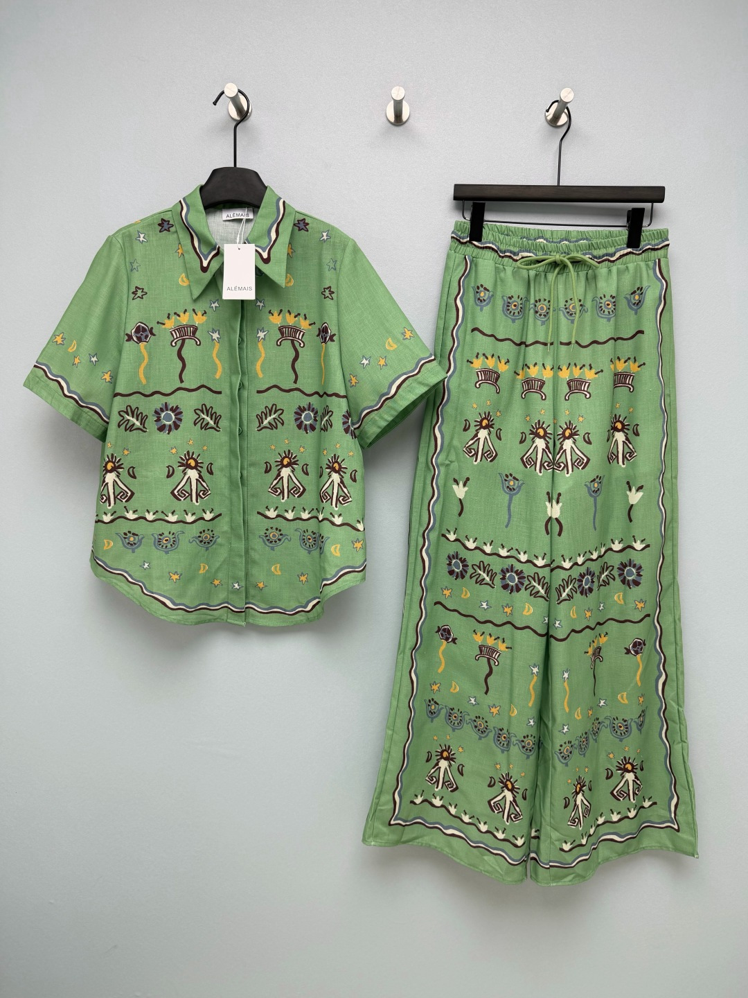 NO:856051,ALEMAI*26 new ethnic style totem cotton suit  It is based on fresh mint green and is paired with hand-painted ethnic totem prints (sun, stars, moon, flowers). It has a bohemian exotic atmosphere. The color is fresh and energetic, and yellow leather can be easily controlled. The lapel short-sleeved trousers design, the top with loose shoulder design, are friendly to all body types. The hidden button design on the front is simple and elegant. The hem is curved and can be worn alone.  They also have a sense of style. The wide-leg pants have an elastic waist and drawstring design, which are easy to put on and take off, and are tolerant to the waist and abdomen; the high-waisted wide-leg version elongates the leg line, has an excellent drape feeling, and has a sense of elegance when walking, hiding the muscles and showing a slimming effect. The iconic retro flower print is presented with a contrasting border, with blue and white contrasting colors and warm brown embellishments, full of Southern French vacation style, with a relaxed atmosphere~  2 colors 4 codes SMLXL, women's clothing, T-shirt,19860909ALEMAI*26新款民族风图腾棉布套装 以清新薄荷绿为基底,搭配手绘感民族图腾印花（太阳、星月、花卉）,自带波西米亚的异域氛围,配色清新又充满活力,黄皮也能轻松驾驭.翻领短袖长裤设计,上衣宽松落肩版型,对各种身材都很友好,前襟隐藏式纽扣设计,简约大气,下摆弧形剪裁,单穿也很有造型感.阔腿裤松紧腰+抽绳设计,穿脱方便,对腰腹包容性强；高腰阔腿版型,拉长腿部线条,垂坠感极佳,行走间自带飘逸感,藏肉显瘦效果拉满.标志性的复古花卉印花以撞色边框呈现,蓝白撞色搭配暖棕点缀,充满南法度假风情,自带松弛氛围感~ 2色4码SMLXL,女装,T-shirt,,Women's clothing