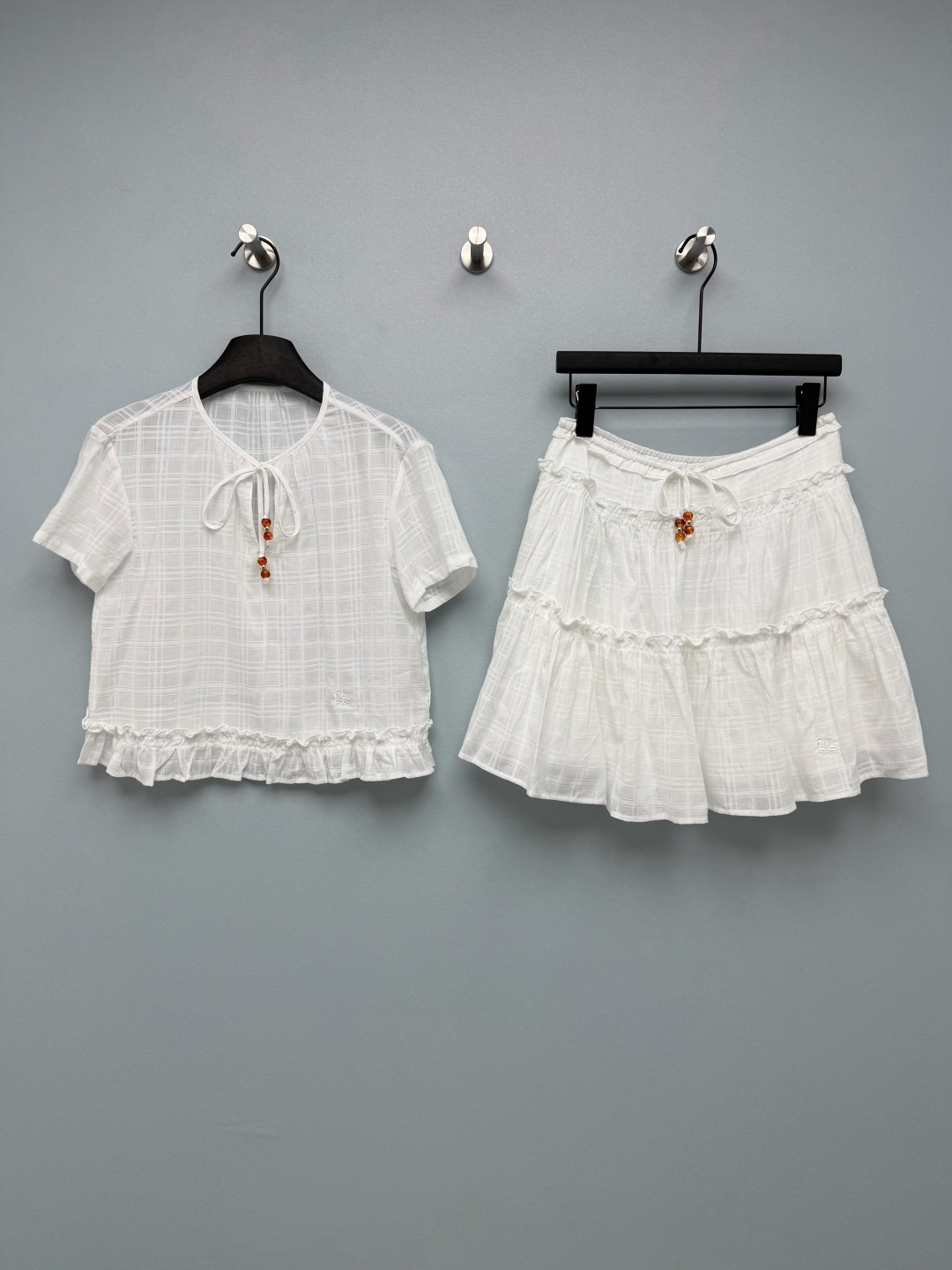 NO:856501,Burberr*26 new cotton suit short-sleeved skirt. The amber beaded tie at the neckline and waist is the finishing touch, retro and gentle, adding a sense of sophistication to the overall look. The multi-layered ear-edge splicing design of the skirt has a fluffy feel, smart and playful, and the embroidered logo on the body is low-key and recognizable, with a full sense of detail. The textured dark plaid fabric is used, with a slight sense of transparency, and the French pastoral flavor is instantly there!  Single color size 3 SML, Burberry-clothing, burberry, skirts, T-shirt,19860909Burberr*26新款棉布套装 短袖短裙 领口和腰头的琥珀串珠系带是点睛之笔,复古又温柔,为整体造型增添了精致感.裙摆的多层木耳边拼接设计,自带蓬松感,灵动俏皮,衣身的刺绣logo低调又有辨识度,细节感拉满.选用肌理感暗格纹面料,自带轻微通透感,法式田园那味儿瞬间就有了！单色3码SML,博柏利-服装,burberry,skirts,T-shirt,,Women's clothing