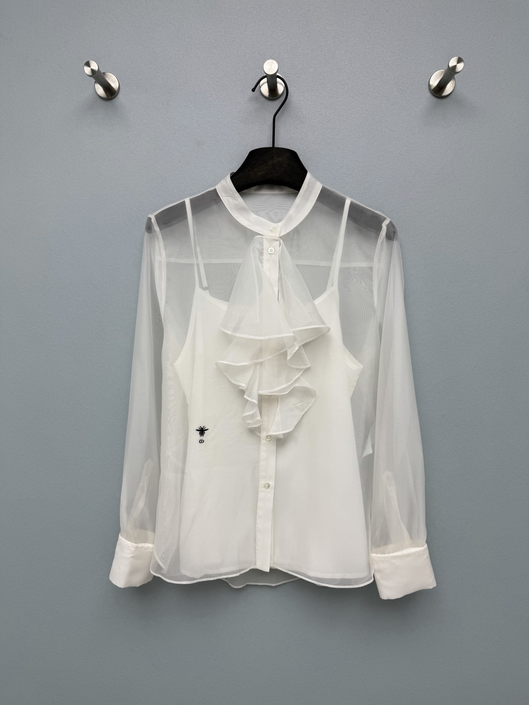 NO:856712,DIO*26's new stand-up collar + front layered ruffled long-sleeved shirt has an elegant French feel. It has a loose and slightly translucent silhouette, which is not flattering on your figure. The upper body looks slim and elegant. It is paired with a suspender of the same color as the inner layer, which is gentle and not exposed!  The white model is clear and gentle, while the black model is mysterious and noble. Both models are versatile!  High-count slightly permeable organza fabric, light and drapey, with a soft light and transparency, the upper body is skin-friendly and breathable, with high-end luster, exquisite bee embroidery on the left chest, low-key and noble!  2 colors and 3 codes SML, Dior-clothing, dior, dior,19860909DIO*26新款立领+前襟层叠荷叶边长袖衬衣 自带优雅法式感,宽松微透廓形,不挑身材,上身显瘦又飘逸,搭配同色系吊带内搭,温柔又不暴露！白款清透温柔,黑款神秘贵气,两款都巨百搭！高支微透欧根纱面料,轻盈垂坠,自带柔光通透感,上身亲肤透气,自带高级光泽,左胸精致蜜蜂刺绣,低调又显贵！2色3码SML,迪奥-服装,dior,dior,,Women's clothing