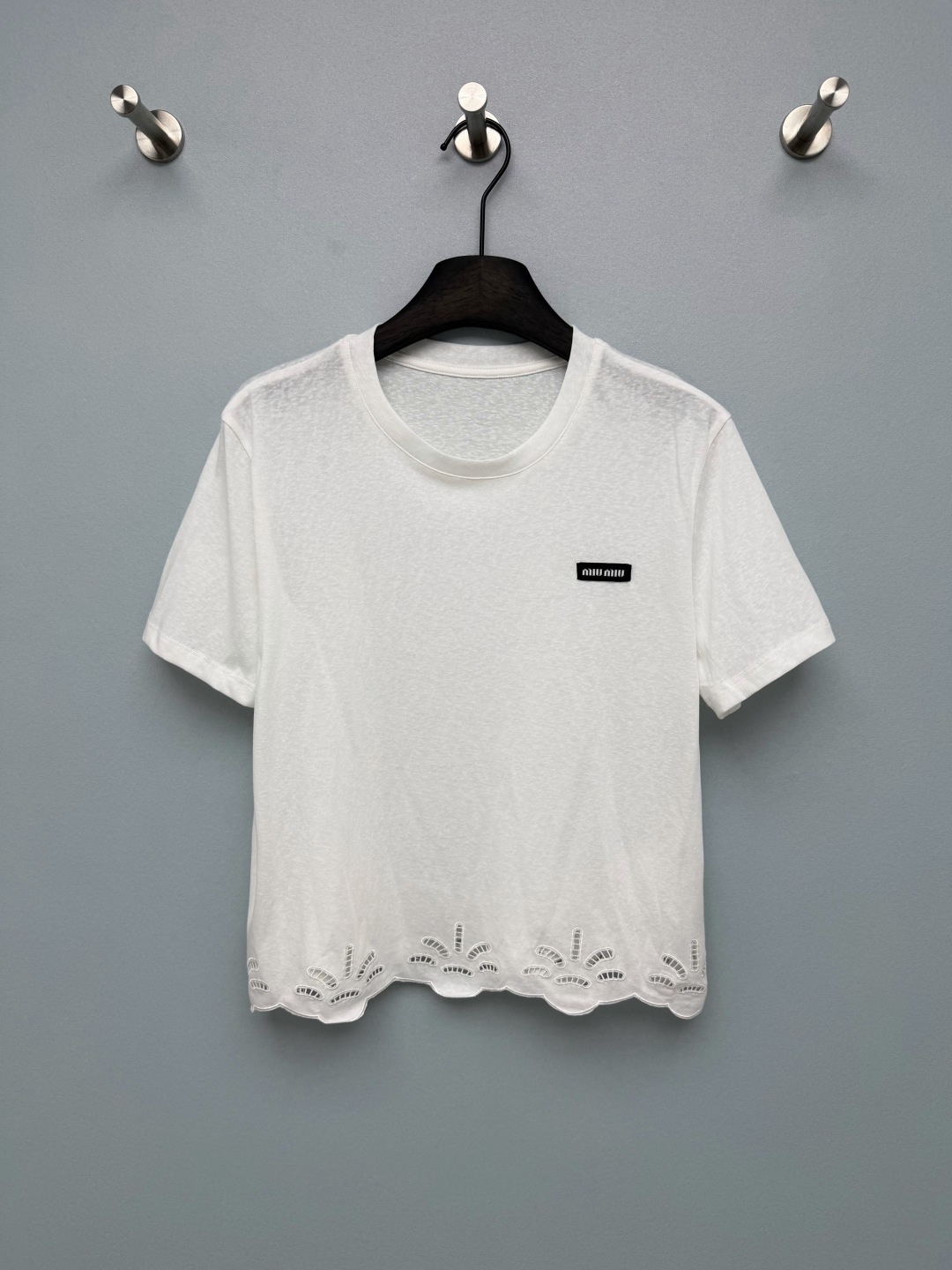 NO:860956,Miu*26 new hollow embroidered hem short-sleeved T-shirt  The fan-shaped hollow embroidery at the hem is the soul highlight of the whole piece. The exquisite handwork breaks the monotony of ordinary white T-shirts. It comes with a soft-focus filter, which is gentle and discreet. The black woven label on the left chest is low-key and recognizable. It injects the brand texture into the simple basic style. The overall exquisiteness and gentleness break the monotony of ordinary white T-shirts. It comes with a soft-focus filter and exudes a girlish look when you raise your hand!  Solid color 3 code R, Miu Miu-clothing, miumiu, T-shirt, tees, t-shirt,19860909Miu*26新款镂空刺绣下摆短袖T恤 衣摆处的扇形镂空刺绣是整件的灵魂亮点,精致的手工感打破了普通白T的单调感,自带柔焦滤镜,温柔又有小心机.左胸的黑色织唛标,低调又有辨识度,为简约的基础款注入品牌质感整体精致又温柔,打破了普通白T的单调感,自带柔焦滤镜,抬手间都在散发少女感！单色3码R,缪缪-服装,miumiu,T-shirt,tees，t-shirt,,Women's clothing