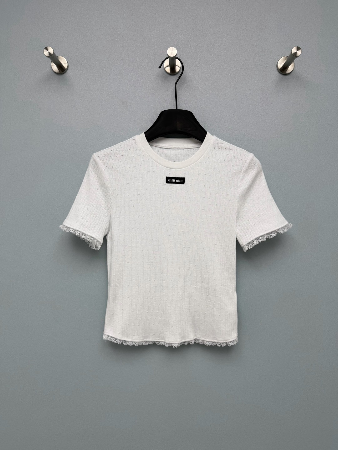 NO:862605,Miu Mi*26 new lace ribbed short-sleeved top. The black woven miu logo on the body is the finishing touch for brand recognition. It is low-key and has a girlish nobility. The lace at the cuffs and hem breaks the basic sense of rib knitting, softens the lines, and has a retro sweet girl atmosphere, which perfectly balances sexiness and purity. Caramel brown is gentle and retro, navy blue is cool and pure, and the high-elastic ribbed fabric upper body is super slim.  The soft lace edges and the sense of detail directly hit me!  2 colors and 3 codes SMLB, Miumiu-clothing, miumiu, T-shirt,19860909Miu Mi*26新款蕾丝花边罗纹短袖上衣 衣身的黑色织唛miu标识,是品牌辨识度的点睛之笔,低调又自带少女贵气感 袖口下摆蕾丝花边,打破了罗纹针织的基础感,柔化线条,自带复古甜妹氛围,完美平衡了性感与清纯.焦糖棕温柔复古,藏青又酷又纯, 高弹力罗纹面料上身超显瘦 软乎乎的蕾丝边,细节感直接戳中我！2色3码SMLB,缪缪-服装,miumiu,T-shirt,,Women's clothing