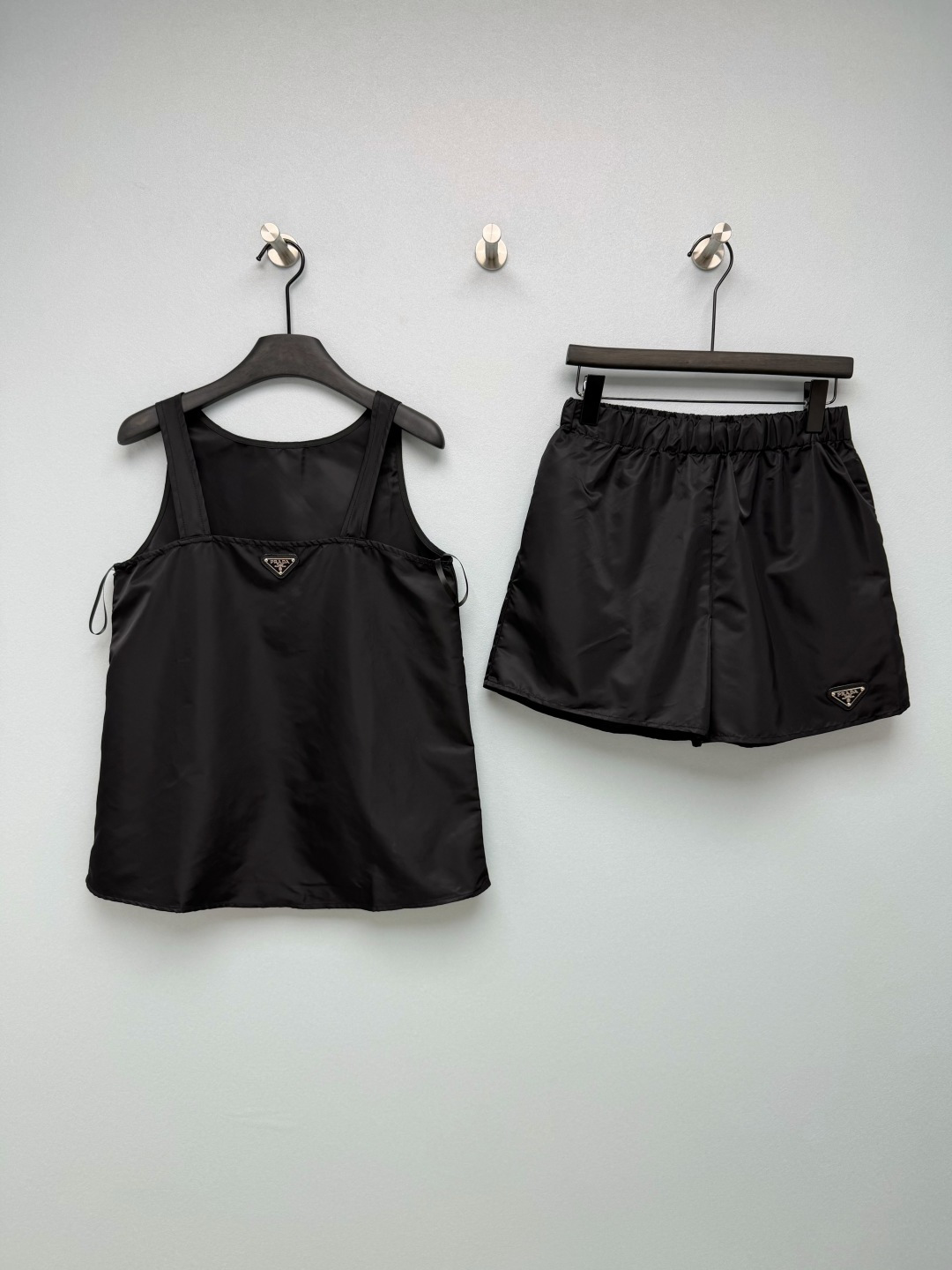 NO:864200,Pra*26 new regenerated nylon suit vest, top and shorts combination. Classic regenerated nylon fabric, matte black high-end feel, waterproof and durable, great for summer. Wide shoulder straps, round neck version, modified shoulder and neck lines, not shoulder-shaped classic enamel triangle metal logo on the chest, full brand recognition, slightly loose A-line hem, hidden flesh and slimming, embellished with the same series of triangle logo on the side of the pants, simple and neat, invisible side pockets are practical~  Monochrome size 3 SMLJ,Prada-clothing,prada,prada,shorts,19860909Pra*26新款再生尼龙套装背心上衣短裤的组合 经典再生尼龙面料,哑光黑高级感拉满,防水耐造夏天巨省心 宽肩带圆领版型,修饰肩颈线条,不挑肩型胸前经典珐琅三角金属标,品牌辨识度拉满,微宽松A字下摆,藏肉显瘦,裤侧点缀同系列三角标,简约利落,隐形侧兜兼顾实用性~ 单色3码SMLJ,普拉达-服装,prada,prada,shorts,,Women's clothing