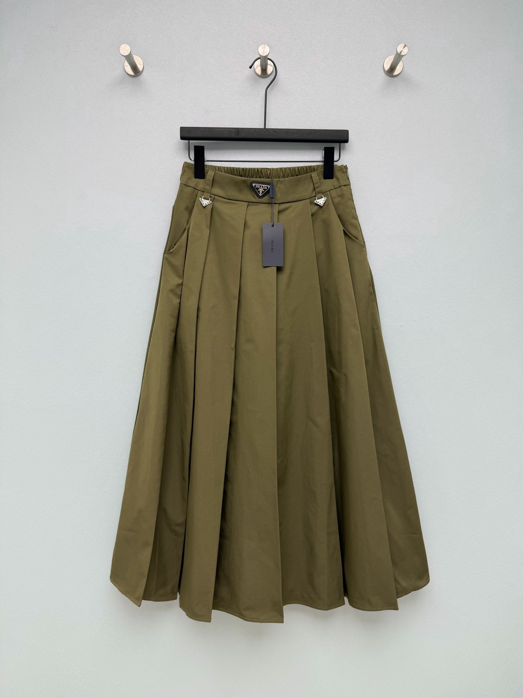 NO:866429,PRA*26 new skirt  The classic black leather triangular metal logo is sewn in the center of the waistband, and the left and right trouser loops are matched with mini triangular metal logos, which are the most recognizable visual symbols; the hangtag is printed with the brand's letter logo, and the front panel is made with three-dimensional pleating technology, which naturally spreads out to form an A-shaped hem.  The mid-length skirt is as long as the length and calf position; the hidden elastic design on the back waist is compatible with various waistlines without constricting the waist; there are practical pockets on the sides; the crisp woven fabric has long-lasting pleats and is not easy to collapse. It has a strong modification effect on wide hips and thick thighs. It is a versatile skirt for thousands of years!  3 colors and 4 codes SMLXLB, Prada-clothing, prada, prada, skirts,19860909PRA*26新款半裙 腰头正中缝制经典黑色皮革三角金属Logo标,左右裤袢搭配迷你同三角金属小标,是辨识度最高的视觉符号；吊牌印有品牌字母标识,前片立体压褶工艺,自然散开形成A字大摆中长裙长,长度及小腿位置；后腰暗藏松紧弹力设计,兼容多种腰围,不勒腰；侧边设有实用插袋；挺括梭织面料,褶型持久不易塌,对胯宽、大腿粗身材修饰力强,万年百搭神裙！3色4码SMLXLB,普拉达-服装,prada,prada,skirts,,Women's clothing