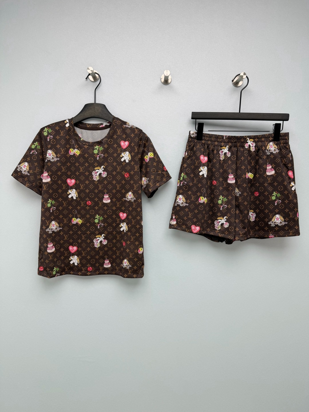 NO:867589,Lou*26 new childlike cartoon mesh short-sleeved shorts two-piece set  The whole body is made of high-elastic breathable honeycomb mesh quick-drying fabric, classic dark brown Monogram presbyopic bottom, superimposed with childlike hand-painted cartoon elements such as lop-eared white rabbits, love balloons, colorful dice, small cakes, four-leaf clover lucky flowers and other sweet patterns, neutralizing the mature and heavy feeling of presbyopia, and giving a sweet and cool girly style. Loose T-shirt + elastic shorts  Comes in one set, lazy people can just put it on when going out. The short sleeves with dropped shoulders do not pick up the shoulders. The shorts are high-waisted to hide the belly. It can be worn with confidence even if you have a pear-shaped body. The color fastness of the printing is online. It will not fade when machine washed. It can be used at home, shopping and vacation. The big-name texture + childlike design make it elegant for daily wear and reduce your age. You just need a casual suit in summer!  Single color code 3 SML, Louis Vuitton-clothing, louis vuitton, shorts, T-shirt, tees, t-shirt,19860909Lou*26新款童趣卡通网眼短袖短裤两件套套装 全身采用高弹透气蜂窝网眼速干面料,经典深棕Monogram老花底,叠加童趣手绘卡通元素垂耳白兔、爱心气球、彩色骰子、小蛋糕、四叶草幸运花等甜萌图案,中和老花成熟厚重感,甜酷少女风拉满.宽松T恤+松紧短裤一套配齐,懒人出门直接套上就走,落肩短袖不挑肩型,短裤高腰藏小肚腩,梨形身材也能放心穿,印花色牢度在线,机洗不掉色,居家、逛街、度假全能hold住,大牌质感+童趣设计,日常穿显贵又减龄,夏天刚需休闲套装！单色3码SML,路易威登-服装,louis vuitton,shorts,T-shirt,tees，t-shirt,,Women's clothing