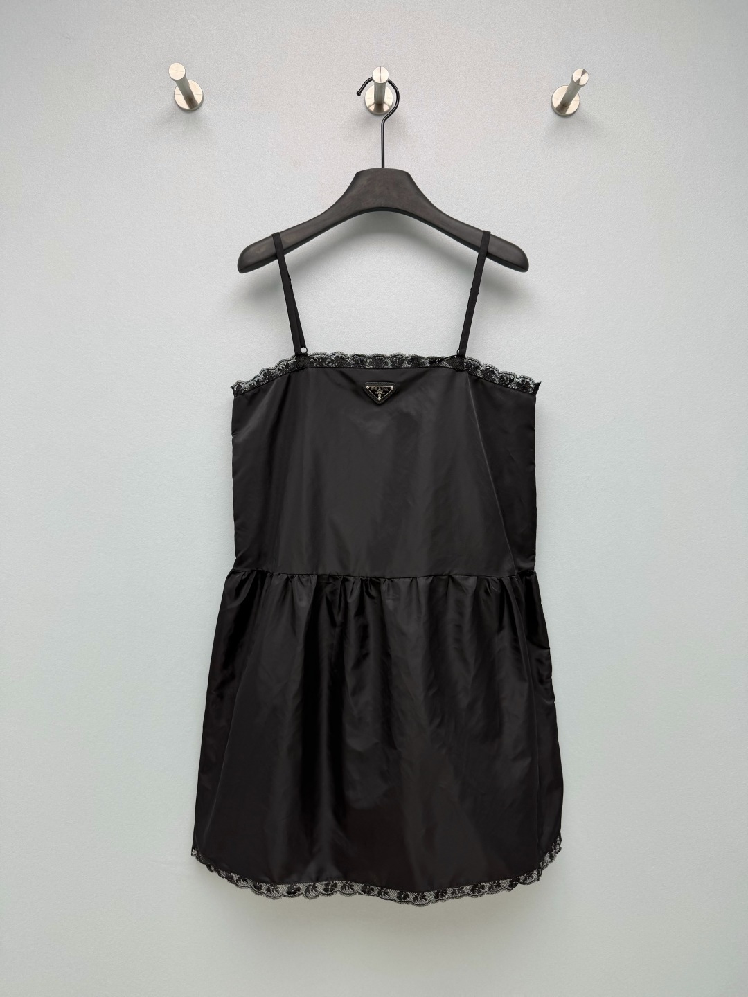 NO:883776,Pra*26 new nylon lace suspender dress  The classic regenerated nylon fabric has a stiff texture and slight luster. It is windproof and wear-resistant, while retaining a light and drapey feel. It is a highly recognizable material for the brand. The straight cut of the upper body, combined with the pleated design at the waist, naturally forms a fluffy A-line skirt. The neckline and skirt edge are spliced with black lace, breaking the toughness of the nylon material and adding a soft girlish atmosphere. The sweet-cool balance is just right, and the details are exquisite!  Single color size 3 SML,Prada-clothing,prada,prada,skirts,19860909Pra*26新款尼龙蕾丝边吊带连衣裙 经典的再生尼龙面料,自带挺括质感与轻微光泽,兼具防风、耐磨特性,同时保留了轻盈垂坠感,是品牌辨识度极高的材质.上半身直筒剪裁,结合腰部打褶设计,自然形成蓬松A字裙摆,领口与裙摆边缘拼接黑色蕾丝,打破尼龙材质的硬朗感,增添柔美的少女氛围,甜酷平衡恰到好处,细节处尽显精致感！单色3码SML,普拉达-服装,prada,prada,skirts,,Women's clothing