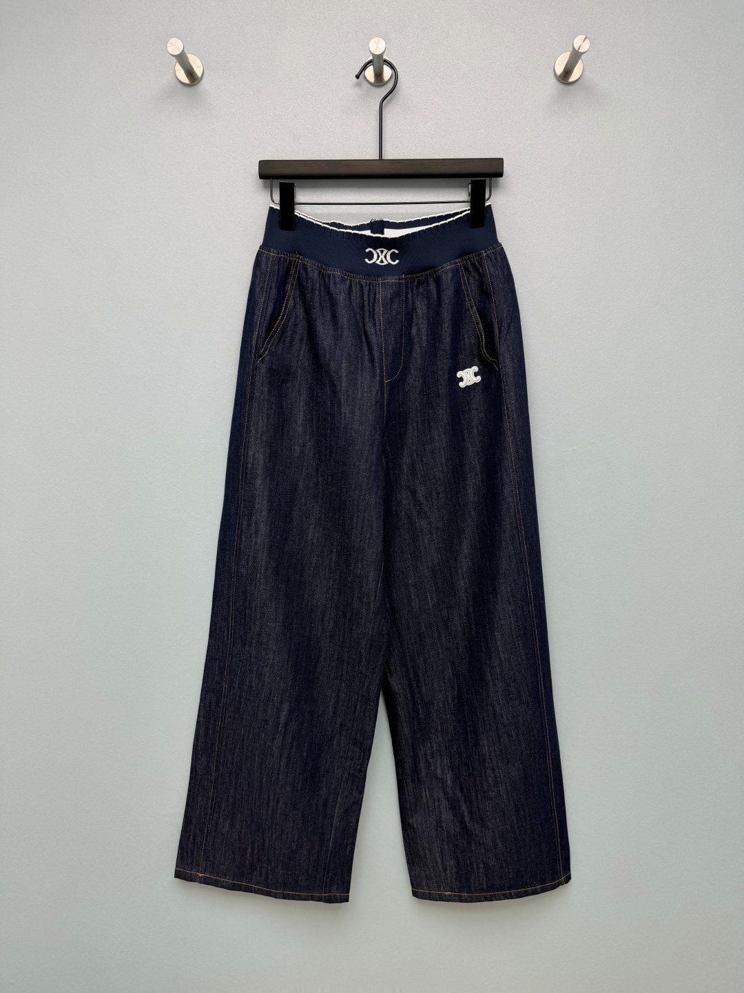 NO:888762,CE*26 new Arc de Triomphe elastic waist denim wide-leg pants. The navy knitted wide waistband is woven with the white Arc de Triomphe logo. The wavy white edge details are full of exquisiteness. The original dark blue is retro and attractive. The classic yellow topstitching restores the retro atmosphere of denim. The small Arc de Triomphe embroidery on the side is low-key and unobtrusive. The diagonal pocket is super convenient for daily use. Paired with a simple white T and a sweater, it has a French relaxed feel. It can be used for commuting to school and shopping!  Monochrome size 3 S, Celine-clothing, celine,19860909CE*26新款凯旋门松紧腰牛仔阔腿裤 藏青针织宽腰头织满白色凯旋门logo,波浪白边细节精致感拉满,原色深蓝复古耐看,经典黄明线还原丹宁复古氛围,侧边小巧凯旋门刺绣低调不张扬,斜插口袋日常放手机超方便 搭配简单白T、针织衫都很有法式松弛感,通勤上学逛街一条搞定！单色3码S,赛琳-服装,celine,,Women's clothing