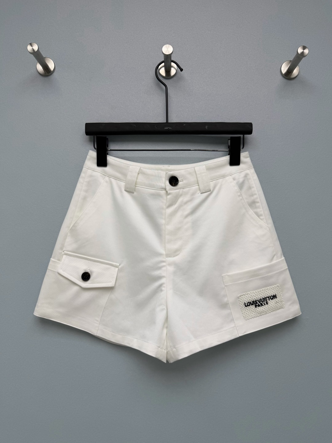 NO:890159,lou*26 new style double pocket embroidered cargo shorts  The small flap pocket on the left side is matched with a resin button of the same color and is cut in three-dimensional work clothes to add a sense of hierarchy; the large patch pocket on the right side is sewn with a grid texture woven label, and the black embroidered brand letters on the woven label are the unified identification element of the entire series, and are embroidered with the linen sleeveless dress  The details are completely echoed, and the matching of the set is coordinated and unified. The asymmetric double work pocket design, the exclusive grid embroidered woven label on the right side is the finishing detail, and it perfectly echoes the embroidery of the dress of the same series. Wearing it as a set directly adds to the atmosphere. The black is slim and cool, and the off-white is gentle and refreshing.  2 colors and 3 sizes SMLR,Louis Vuitton-clothing,louis vuitton,skirts,shorts,19860909lou*26新款双口袋刺绣工装短裤 左侧小翻盖口袋,搭配同色系树脂扣,立体工装剪裁,增加层次感；右侧大贴袋袋身缝制网格肌理织唛,织唛上黑色刺绣品牌字母,是整套系列统一识别元素,和亚麻无袖连衣裙刺绣细节完全呼应,成套搭配协调统一,不对称双工装口袋设计,右侧专属网格刺绣织唛是点睛细节,和同系列连衣裙刺绣完美呼应,成套穿氛围感直接拉满,黑色显瘦酷飒,米白温柔清爽 2色3码SMLR,路易威登-服装,louis vuitton,skirts,shorts,,Women's clothing