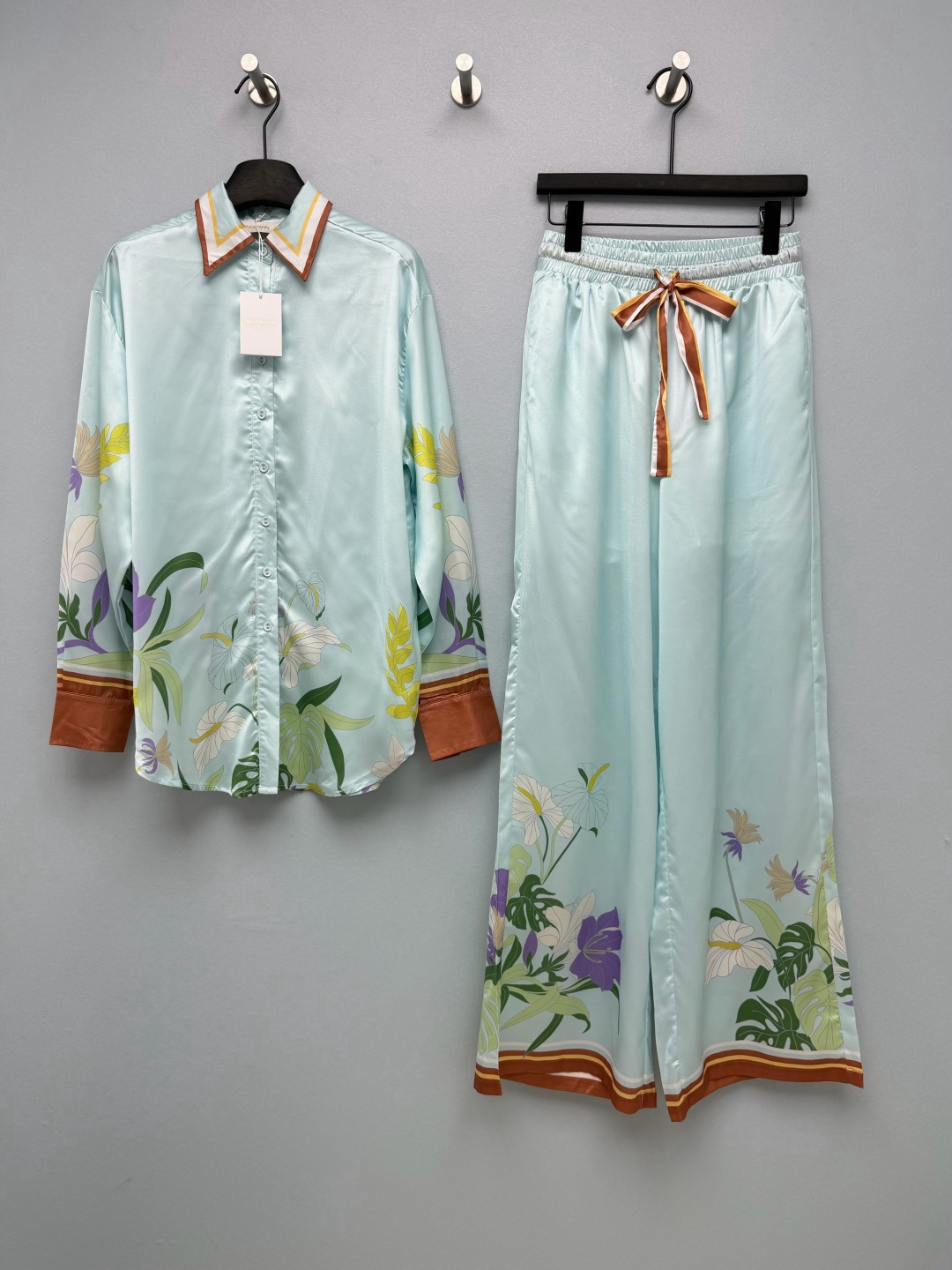 NO:891813,ZIMMERMA's latest mint green tropical floral suit, a combination of shirt and trousers, brings the holiday atmosphere into daily life. The clear mint base color is combined with retro tropical plant prints to create a lazy and relaxed southern French holiday atmosphere. The body and trouser legs adopt symmetrical floral patterns, with monstera, lilies and pansy arranged at random, and the colors are soft and elegant.  The collar, cuffs, and trouser legs are uniformly spliced with caramel-colored contrasting webbing, and the striped edging forms a complete visual closed loop, with exquisite and unified details. The lapel long-sleeved shirt has a loose shoulder cut, single-row button closure, and is not tight or restrictive. The cuffs are cuffed with contrasting colors, neat and stylish, and suitable for home and outdoor wear. The high-waisted elastic waist wide-leg trousers are paired with striped drawstrings of the same color to freely adjust the waistline.  The trouser legs drape and stretch, and the trouser legs continue to be hemmed in contrasting colors to modify the shape of the legs and create an elegant drape when walking!  Single color code 4 SMLXL, Zimmerman-clothing, shirts,19860909ZIMMERMA*新款薄荷绿热带花卉套装 衬衣长裤的组合 把度假氛围穿进日常 清透薄荷底色,糅合复古热带植物印花,营造慵懒松弛的南法度假氛围.衣身与裤腿采用对称花卉图案,龟背竹、百合与紫堇错落排布,色彩柔和雅致. 领口、袖口、裤脚统一拼接焦糖色撞色织带,条纹镶边形成完整视觉闭环,细节精致统一.翻领长袖衬衫版型,宽松落肩剪裁,单排纽扣开合,不紧绷不束缚.袖口做收口撞色设计,利落有型,居家外穿都得体.高腰松紧腰阔腿长裤,搭配同色系条纹抽绳,可自由调节腰围. 裤腿垂坠舒展,裤脚延续撞色包边,修饰腿型,走路自带飘逸垂感！单色4码SMLXL,兹默曼-服装,shirts,,Women's clothing