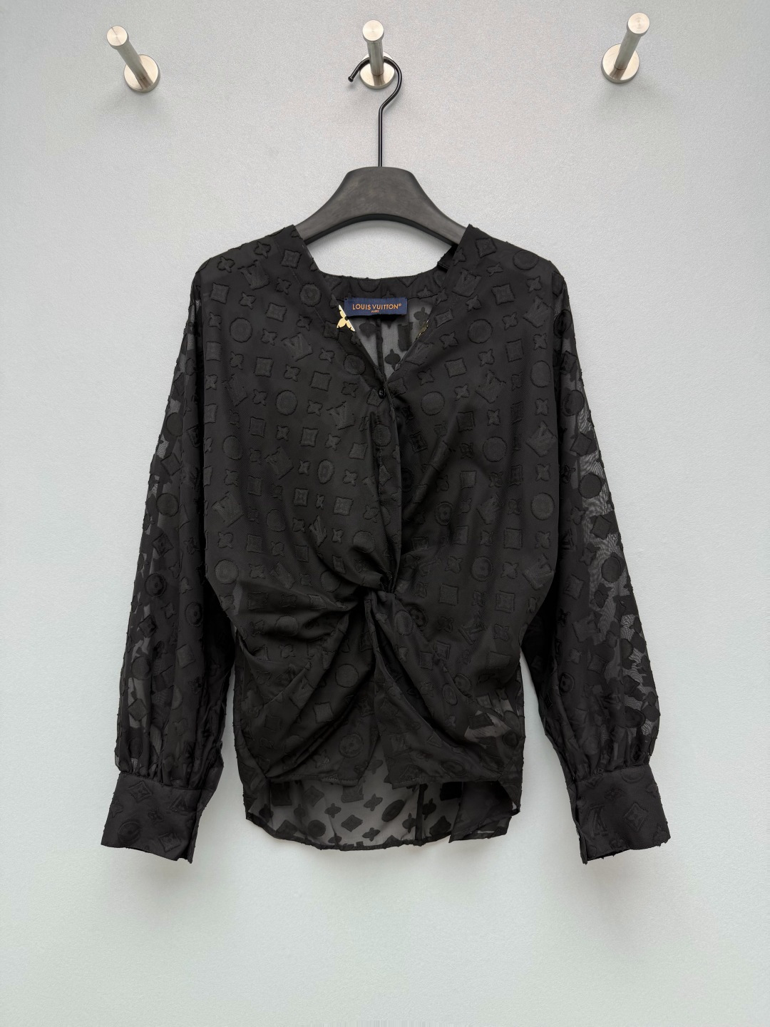 NO:899706,lou*Full-width flocked dark pattern twisted V-neck see-through shirt. It has a thin georgette base fabric, and the upper body is elegant and soft. With the three-dimensional flocking presbyopia dark pattern on the surface, it has a faint texture, which is transparent and high-end without being tacky. The twist and pleat design on the front waist cleverly raises the waistline, optimizes the body proportions, and can also hide the fat on the lower abdomen. The V-neck is equipped with exclusive gold metal buttons, and the cuffs of the shirt modify the arm lines, which is gentle and a little sexy.  Solid color size 3 SML,Louis Vuitton-clothing,louis vuitton,shirts,19860909lou*满幅植绒暗纹扭结V领透视衬衫 轻薄乔其纱底布,上身飘逸柔和,加上表层的立体植绒老花暗纹,若隐若现的肌理感,通透高级不会俗气；前身腰部扭结收褶设计,巧妙拉高腰线,优化身材比例,还能遮挡小腹赘肉；V领搭配专属金色金属扣,收口衬衫袖口修饰手臂线条,温柔又带点小性感. 单色3码 SML,路易威登-服装,louis vuitton,shirts,,Women's clothing