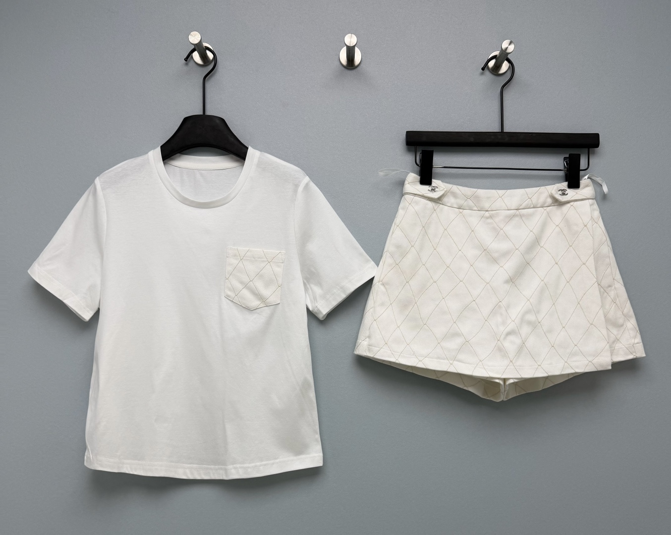 NO:900178,Cha* diamond pocket T-shirt pants suit  The pockets and culottes are all made of rhombus stitching technology, which echoes the whole series and has a high-end sense of complete set. The top is a basic round-neck short-sleeved T-shirt, and the body is made of flat and skin-friendly combed cotton. The pockets on one side are spliced with rhombus quilting fabric of the same fabric. The simple basic style adds a sense of exquisite design, with a loose and slightly dropped version, the upper body is comfortable and not tight; the bottom  The outer version of the trouser skirt is an A-line skirt style, which visually makes the legs longer. It comes with shorts on the inside, which completely solves the concern of exposure, and is safe for daily commuting and traveling. The waist is equipped with metal decorative buckles, which is exquisite and light luxury.  Two-color code 3 SMLR, Chanel-clothing, chanel, skirts, shorts, T-shirt, tees, t-shirt,19860909Cha*菱格口袋T恤裤裙套装 口袋和裙裤全部采用菱形压线工艺,整套系列呼应,高级成套感,上衣是基础圆领短袖T恤,衣身是平整亲肤的精梳棉,单侧口袋拼接同面料菱格绗缝面料,简约基础款增加精致设计感,宽松微落版型,上身舒适不紧绷；下装裤裙外版是A字短裙版型,视觉显腿长,内里自带短裤,彻底解决走光顾虑,日常通勤、出行都安心,腰部配有金属装饰扣,精致轻奢,通体菱格压线,面料挺括,高腰设计拉高腰线.浅蓝米白两色可选,成套穿省时也省心 双色3码 SMLR,香奈儿-服装,chanel,skirts,shorts,T-shirt,tees，t-shirt,,Women's clothing