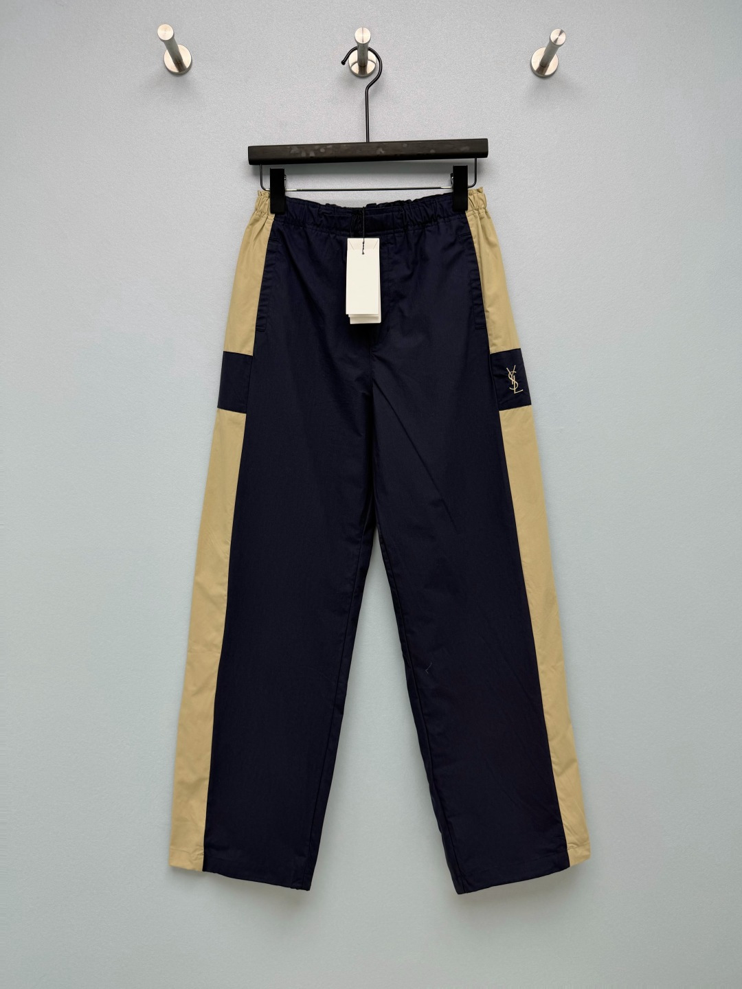 NO:941122,Ysl* navy color block wide-leg casual trousers  Made of light and thin woven workwear fabric, the fabric surface is smooth and smooth, with good air permeability and slight stiffness. The YSL small gold logo is embroidered in a small square on the side of the pants, which is low-key and unobtrusive, and reflects the texture just right. The elastic drawstring waist is very tolerant to the waist and abdomen, and is loose and wide  The leg trousers type can easily modify the shape of the legs and bring a sense of laziness and relaxation. The loose straight wide-leg version can modify the shape of the legs and visually elongate the lines. The side pocket design is practical. The navy blue background color is matched with side khaki contrast stitching and segmented color block design, which is retro and sporty.  Monochrome size 3 SML B, saint laurent-clothing, saint laurent, saint laurent,19860909Ysl* 藏青拼色阔腿休闲长裤 选用轻薄梭织工装面料,布面平整顺滑,透气度良好,带有轻微挺括度.裤侧小方块刺绣YSL小金标,低调不张扬,恰到好处地体现质感.松紧抽绳腰头,对腰腹包容性很强,宽松阔腿裤型,轻松修饰腿型,自带慵懒松弛感.宽松直筒阔腿版型,修饰腿型,视觉拉长线条,侧边插袋设计兼顾实用.藏青底色搭配侧边卡其撞色拼接,分段式色块设计,复古又有运动调性 单色3码 SML B,圣罗兰-服装,saint laurent,saint laurent,,Women's clothing