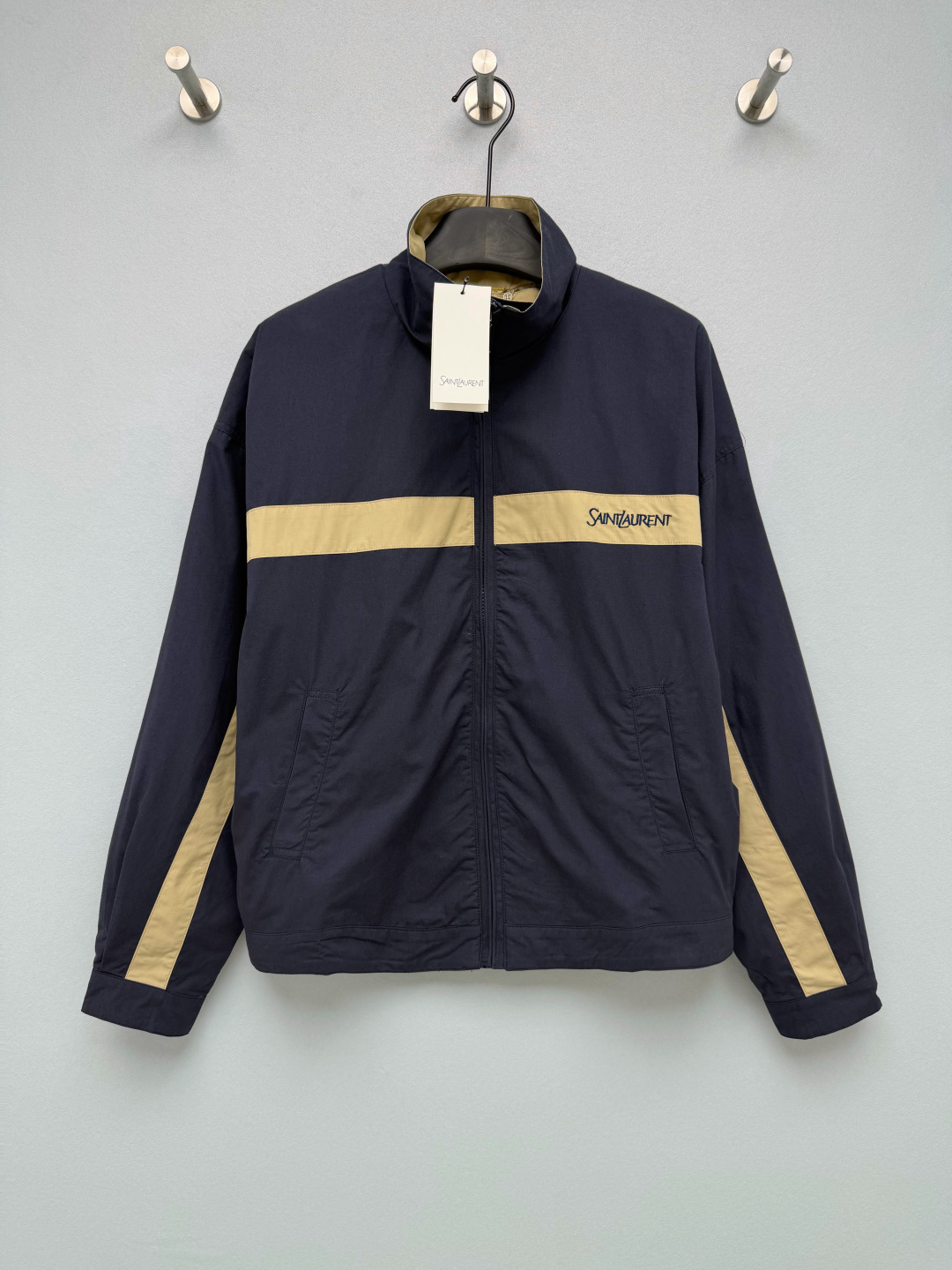 NO:941127,Ysl* navy blue color-blocked stand-collar sports jacket is made of light and thin woven workwear fabric, which is smooth and flat to the touch, with slight windproof properties. The fabric is breathable and not stuffy, crisp and stylish. The navy background color is matched with khaki contrasting webbing, and the chest + sleeve side splicing design is full of retro American atmosphere. Handwritten SAINT is embroidered on the webbing.  The LAURENT letters are low-key and not exaggerated, and the details and texture are in place. The stand-up collar zipper is a basic version, the cuff buttons can be adjusted freely, the loose shoulder cut is not picky about the body shape. The American retro-style stand-up collar jacket, contrasting color design + delicate embroidery, is a versatile style for daily use in spring and autumn. Monochrome 3-code SML B, Saint Laurent-Clothing, saint laurent, saint laurent, saint laurent, jackets & coats, jackets & coats,19860909Ysl*藏青拼色立领运动夹克 选用轻薄梭织工装面料,触感顺滑平整,带有轻微防风属性,面料透气不闷,挺括有型.藏青底色搭配卡其色撞色织带,胸前+袖侧拼接设计,复古美式氛围拉满.织带上刺绣手写SAINT LAURENT字母,低调不浮夸,细节质感很到位.立领拉链基础版型,袖口纽扣可以自由调节,宽松落肩剪裁,不挑身形.美式复古风立领外套,撞色设计+细腻刺绣,春秋日常百搭款.单色3码 SML B,圣罗兰-服装,saint laurent,saint laurent,saint laurent,jackets & coats,jackets & coats,,Women's clothing