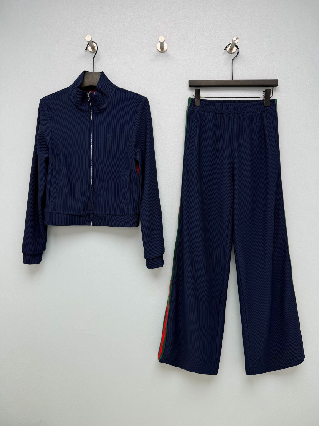 NO:943180,Gu* navy pitted webbing sports suit  Stretch pitted knitted fabric has clear texture, soft and skin-friendly, moderate elasticity, breathable and comfortable. Classic stand-up collar + metal zipper opening and closing, tightened cuffs, simple and casual. Double G embroidery logo in the same color on the body, low-key and refined. Side pocket design, taking into account practicality. Classic red and green webbing on the side of the trousers, complex  Full of vintage recognition. Elastic waisted wide-leg pants, not picking at the crotch, no constraints for daily wear. The top is a short stand-collar zipper jacket, neatly cut to raise the waistline. The bottoms are high-waisted wide-leg trousers, which have good drape, modify the shape of the legs, hide the muscles and make the body look slimmer. The navy blue retro webbing is so elegant, I have found a comfortable outfit for going out!  Single color size 3 SML, Gucci-clothing, gucci, jackets & coats,19860909Gu* 藏青色竖坑条织带运动套装 弹力坑条针织面料,肌理清晰,柔软亲肤,带有适度弹力,透气舒适.经典立领+金属拉链开合,袖口收紧,简约休闲.衣身同色双G刺绣标识,低调精致.侧边口袋设计,兼顾实用性.裤身侧边经典红绿织带,复古辨识度拉满.松紧腰阔腿裤,不挑胯部,日常穿着无束缚.上衣短款立领拉链外套,利落剪裁拉高腰线.下装高腰阔腿长裤,垂感良好,修饰腿型,藏肉显瘦.藏青复古织带太显气质,一套出门的舒适穿搭找到了！ 单色3码 SML,古驰-服装,gucci,jackets & coats,,Women's clothing