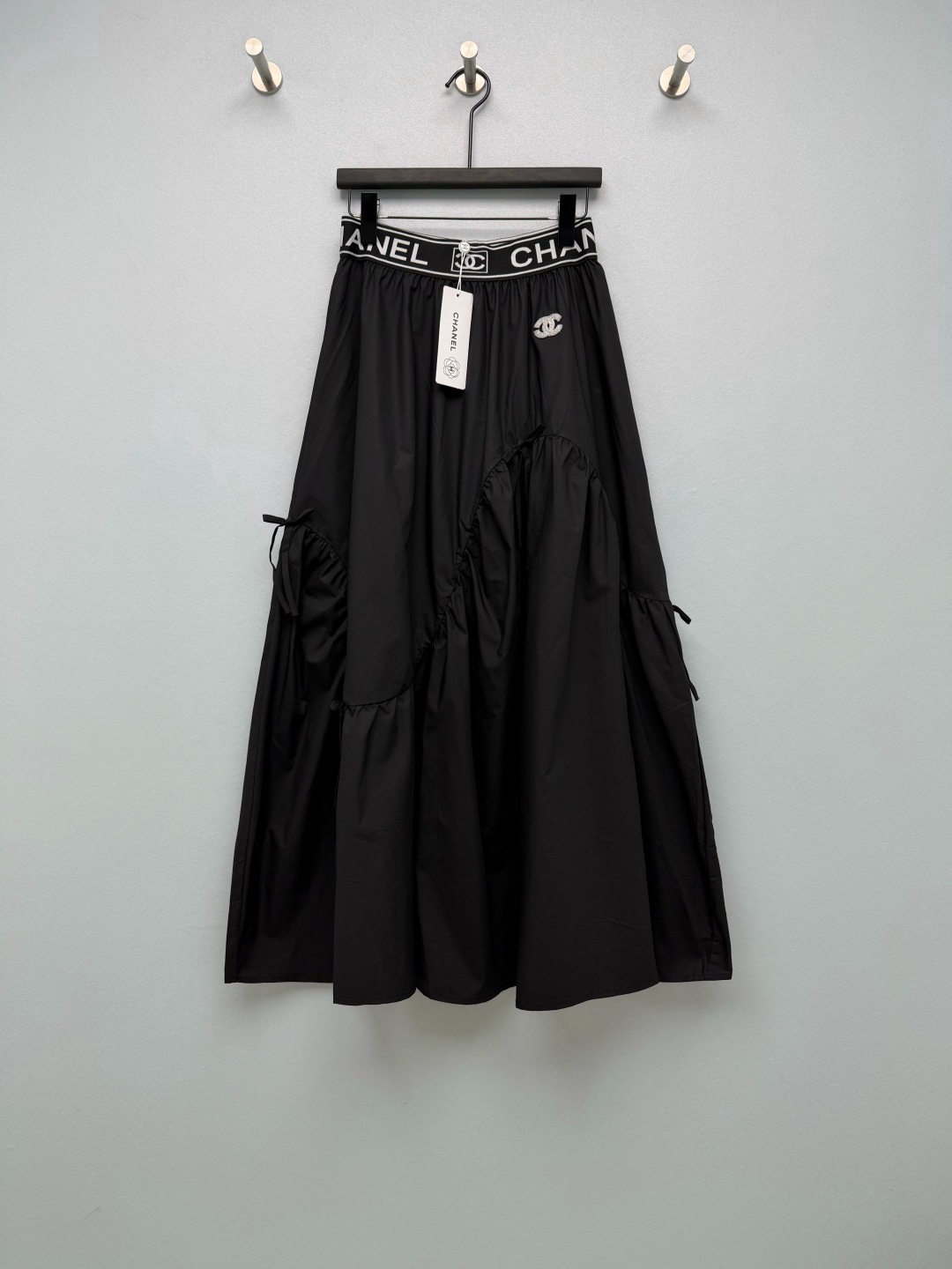 NO:943794,cha* letter waist irregular long skirt  Made of crisp and smooth cotton blended fabric, it has good drape, the shape is not easy to collapse, and the upper body is breathable and refreshing. The wide elastic waist design is printed with the brand letter logo, making it highly recognizable and easy to put on and take off. The double C embroidery logo on the side of the skirt is exquisite and low-profile.  The tone is enhanced to enhance the overall sense of sophistication. Multiple bow pleat designs create a versatile and three-dimensional skirt shape that is casual and relaxed. Irregular splicing pieces break the monotony of ordinary skirts and create a strong sense of atmosphere when walking around. Classic black and white, versatile and easy to match.  Two-color code 4 SMLXL, Chanel-clothing, chanel, skirts,19860909cha* 字母腰头不规则长款半身裙 选用挺括顺滑的棉质混纺面料,垂坠感佳,版型不容易软塌,上身透气清爽.宽版松紧设计腰头,印有品牌字母标识,辨识度拉满,穿脱简单.裙身侧边双C刺绣标,做工精致低调,提升整体精致感.多处蝴蝶结褶皱设计,打造多变立体的裙摆造型,随性松弛.不规则拼接裁片,打破普通半裙的单调感,大摆量走动氛围感很强.经典黑白两色,百搭不出错 双色4码 SMLXL,香奈儿-服装,chanel,skirts,,Women's clothing