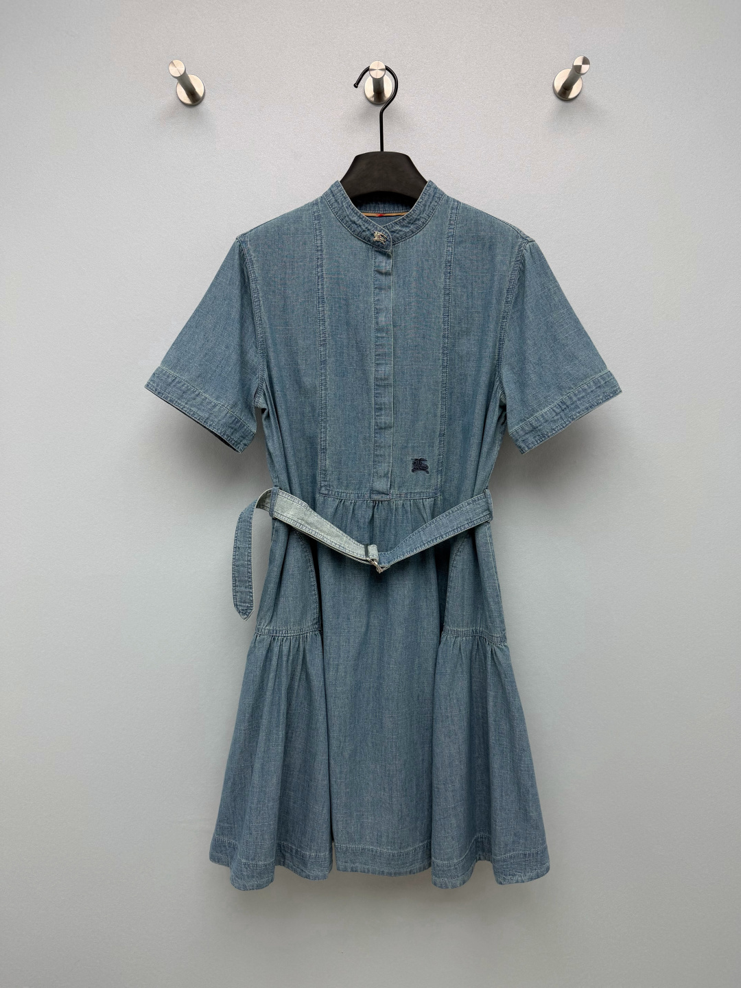 NO:946604,BUR* stand collar washed denim short-sleeved dress  Light and thin washed chambray denim fabric, washed and distressed, soft and breathable, without the bulkiness of thick denim, light blue retro color, refreshing upper body in summer. Small stand-up collar shape, metal war horse logo buckle on the collar, half placket, easy to put on and take off, details full of brand recognition. The chest of the dress  The dark war horse embroidery is low-key and unobtrusive. The denim belt of the same color is adjustable and elastic, and can easily raise the waistline to optimize the body proportions. The top-stitched splitting process on the body adds a sense of layering; the waist is pleated and spliced, and the lotus leaves are large, making walking smart and elegant. The light-wash denim skirt with a retro filter is very practical!  Single color size 3 SML, Burberry-clothing, burberry, skirts, T-shirt,19860909BUR* 立领水洗牛仔短袖连衣裙 轻薄水洗青年布牛仔面料,经过水洗做旧处理,质地柔软透气,没有厚牛仔的笨重感,浅蓝色复古色调,夏日上身清爽.小立领造型,领口金属战马logo扣,半开襟门襟,穿脱便捷,细节充满品牌辨识度.衣身胸口位置深色战马刺绣,低调内敛,不张扬.同色系牛仔腰带,可调节松紧,轻松拉高腰线优化身材比例.衣身明线分割工艺,增加层次感；腰部碎褶拼接,荷叶大摆,走动灵动飘逸.自带复古滤镜的浅水洗牛仔裙,实穿度拉满！ 单色3码 SML,博柏利-服装,burberry,skirts,T-shirt,,Women's clothing