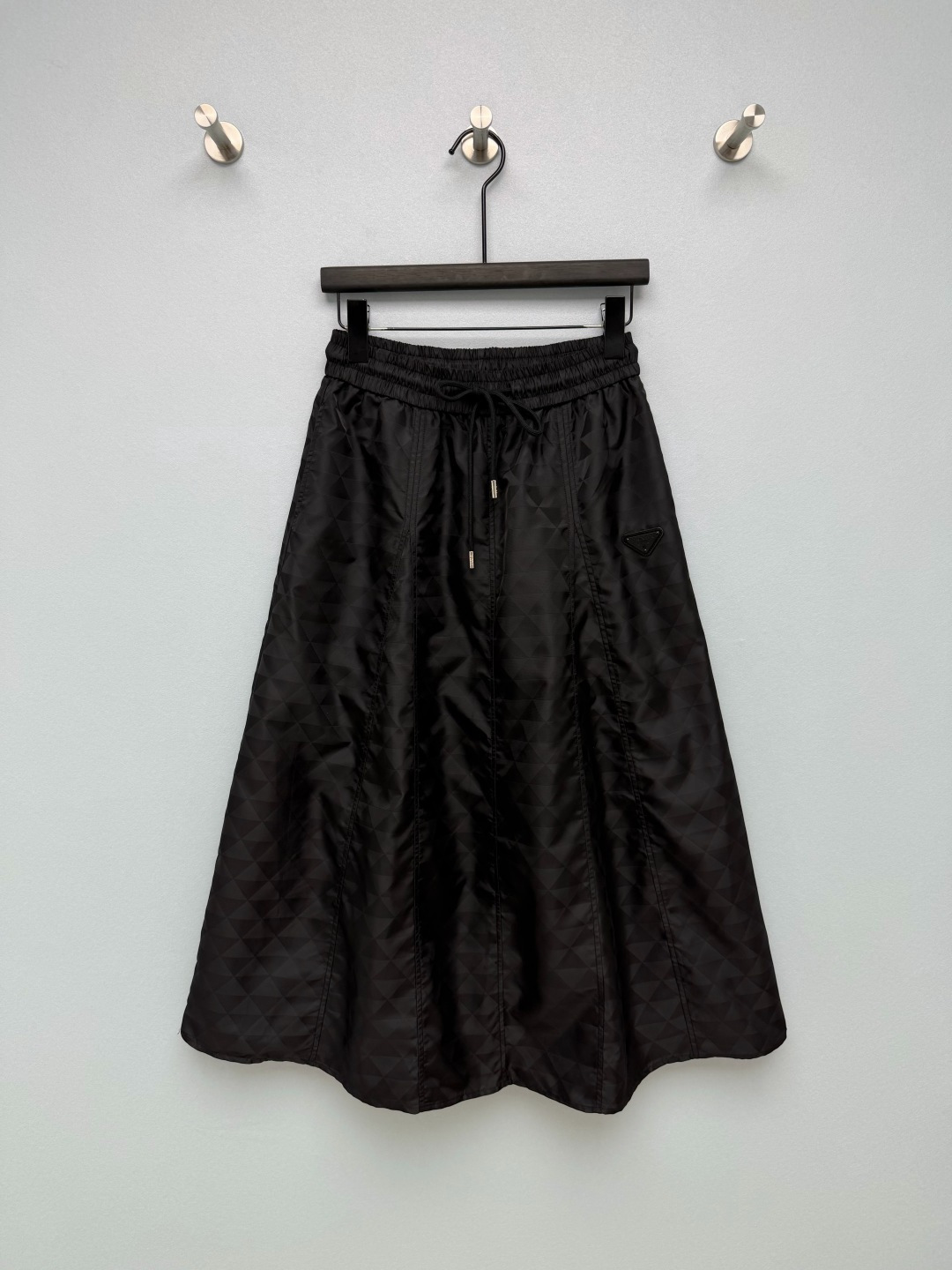 NO:946679,PRA* dark pattern triangle jacquard elastic waist A-line midi skirt  Nylon jacquard fabric, the body is covered with triangular dark pattern jacquard, matte texture, anti-wrinkle and easy to take care of, with its own stiffness, which can support the silhouette of the skirt. The whole body is printed with low-key triangular dark pattern jacquard, with dark patterns of the same color, low-key and high-end, with a sense of hierarchy if you look closely. The classic metal triangle nameplate on the side, the brand's iconic logo, is of high quality  It has an outstanding feel. The elastic waist is matched with a drawstring tie, which can be adjusted freely. It is easy to put on and take off and adapts to a variety of body types. The three-dimensional cutting process allows the skirt to hang naturally and spread out, and has a flexible arc when walking. The large A-line skirt, mid-length, modifies the lines of the crotch and legs. A complete set of dark pattern skirt that directly stretches the body.  Single color size 3 SML,Prada-clothing,prada,prada,skirts,19860909PRA*暗纹三角提花松紧腰A字半身中长裙 尼龙提花面料,衣身满幅三角暗纹提花,哑光质感,抗皱好打理,自带挺括度,能够撑起裙摆廓形.全身满印低调三角暗纹提花,同色系暗纹,低调高级,细看富有层次感.侧边经典金属三角铭牌,品牌标志性标识,质感出众.松紧腰搭配抽绳系带,可自由调节松紧,穿脱简单,适配多种身材.分片立体裁片工艺,让裙摆自然垂坠散开,走动自带灵动弧度.A字大裙摆,中长长度,修饰胯部与腿部线条.成套感直接拉满的暗纹半身裙 单色3码 SML,普拉达-服装,prada,prada,skirts,,Women's clothing