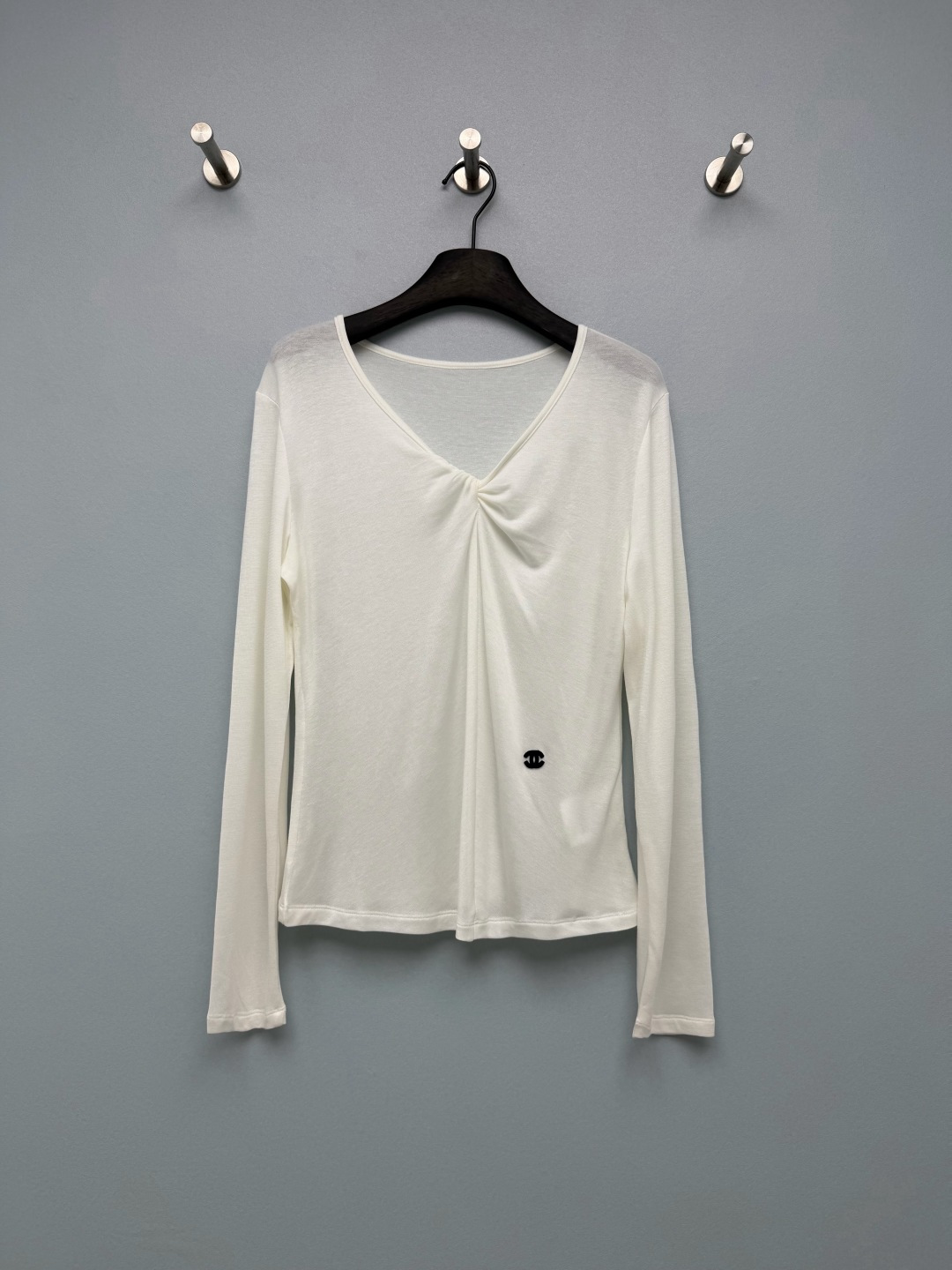 NO:946948,CHA* twist V-neck slim long-sleeved bottoming T-shirt  High elasticity and skin-friendly Tencel knitted fabric, light and slightly translucent with a soft matte texture, enough elasticity to fit the body shape, breathable and not stuffy. The kink V-neck design on the chest moderately exposes the skin and elongates the neck. The simple middle belt is discreet, weakening the shoulder width and modifying the round face. The mini double C embroidered logo on the side of the hem is small, low-key and exquisite.  Not ostentatious. Neat narrow-edged round cuffs, simple and versatile without being cluttered. Available in two colors: milk white, gentle and clean, pure black, slim and high-end, suitable for all bottoms. Short waist cut, just right to tighten the waistline and show proportion; slim and slightly elastic version, outline the shoulder and neck lines without being tight, long sleeves to modify arm fat. Two-color code 3  SML, Chanel-clothing, chanel, tees, t-shirt,19860909CHA*扭结V领修身长袖打底T恤 高弹亲肤天丝针织面料,轻薄微透自带柔润哑光质感,弹力充足贴合身形,透气不闷.胸前扭结V领设计,适度露肤拉长脖颈,简约中带小心机,弱化肩宽、修饰圆脸.下摆侧边迷你双C刺绣标识,小巧低调,精致不张扬.利落窄边圆袖口,简约百搭不拖沓.双色可选奶白温柔干净、纯黑显瘦高级,适配所有下装.短款收腰剪裁,恰到好处收束腰线显比例；修身微弹版型,勾勒肩颈线条不紧绷,长袖修饰手臂赘肉.双色3码 SML,香奈儿-服装,chanel,tees，t-shirt,,Women's clothing