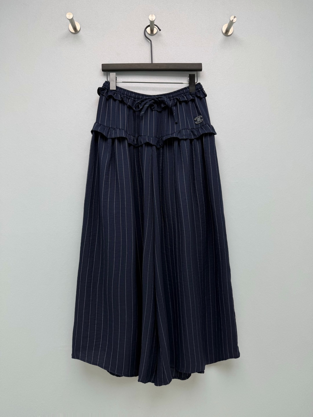 NO:947056,CHA*Vertical stripes fungus hem elastic waist wide leg culottes  Vertical striped cotton and linen blended fabric with a herringbone texture, fine, crisp and breathable, with a soft matte texture, light and not close to the body, with a natural micro-wrinkle atmosphere, making it dry and comfortable to wear in spring and summer, and not easy to sweat. The fully elastic drawstring waistband, matched with laces made of the same fabric, has elasticity that adapts to various waistlines, making it easy to put on and take off without restraint. The double-layer three-dimensional fungus layered design adds a sweet girlish look and weakens the waistline.  Swollen. Exquisite double C embroidered cloth label on the waist, low-key and exquisite in the same color, enhances the recognition of the item. High waistline, double-layer fungus cut, natural pleats on the waist and abdomen, softly covering the lower abdomen, hip width, and thigh fat. Two colors are available, off-white, gentle and fresh, and navy blue, calm and intellectual, suitable for a variety of tops. Skirt-style wide-leg trousers look like a long skirt, and the inner trousers design completely eliminates exposure!  Two-color code 3 SML, Chanel-clothing, chanel, skirts,19860909CHA*竖条纹木耳边松紧腰阔腿裙裤 人字纹肌理竖条纹棉麻混纺面料,肌理细腻挺括透气,自带柔和哑光质感,轻薄不贴身,自带天然微皱氛围感,春夏穿着干爽舒适,不易闷汗.全松紧抽绳腰头,搭配同面料系带,弹力适配各类腰围,穿脱自在无束缚.双层立体木耳边分层设计,增添甜美少女感,弱化腰部臃肿.腰侧精致双C刺绣布标,同色系低调精致,提升单品辨识度.高腰线双层木耳边分割剪裁,腰腹自然堆褶,柔和遮盖小腹、胯宽、大腿赘肉.双色可选米白温柔清新、藏青沉稳知性,适配多种上衣搭配.裙式阔腿裤型,外观酷似长款半身裙,内里裤装设计彻底杜绝走光！ 双色3码 SML,香奈儿-服装,chanel,skirts,,Women's clothing