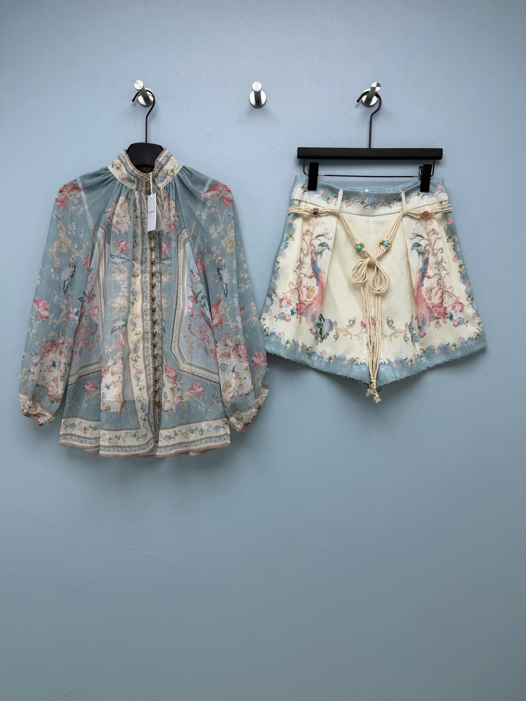 NO:948080,ZIMM* blue flower and bird print stand-collar shirt + high-waisted linen wide-leg shorts two-piece set  The semi-transparent georgette with fine gold silk texture is light and transparent, with its own shimmer, drape and breathable, and does not feel stuffy when worn in spring and summer. The top is a thin georgette with fine gold wire, which has a semi-transparent and soft light texture. The peony and peacock print on the fog blue background is gentle and healing. A row of gold and diamond ball button buttons adds a sense of sophistication, and the lights  The long sleeves hide the fleshy arms. The bottoms are linen fake culottes, which are very girly. The high-waisted wide-leg version hides the crotch and legs. The sides are perfectly matched with the printed splicing and the top. It comes with a turquoise and jade woven belt. Tie a bow at will to reveal the waistline. The whole set is a retro flower-and-bird two-piece set that directly adds to the atmosphere!  Single color code 4 SMLXL, Zimmerman-clothing, skirts, shorts, shirts,19860909ZIMM* 蓝底花鸟印花立领衬衫+高腰亚麻阔腿短裤两件套 带细金丝肌理的半透乔其纱,轻薄通透,自带微光细闪,垂坠透气,春夏穿着无闷热感.上衣是带细金丝的薄款乔其纱,半透柔光质感,雾蓝底牡丹孔雀印花温柔又治愈,一整排金钻圆珠扣精致感拉满,灯笼长袖藏住手臂肉肉.下装亚麻假裙裤太懂女生,高腰阔腿版型藏胯藏腿,侧边同印花拼接和上衣完美成套,附赠松石玉石编织腰带,随意系个蝴蝶结腰线立刻显现.整套氛围感直接拉满的复古花鸟两件套！ 单色4码 SMLXL,兹默曼-服装,skirts,shorts,shirts,,Women's clothing