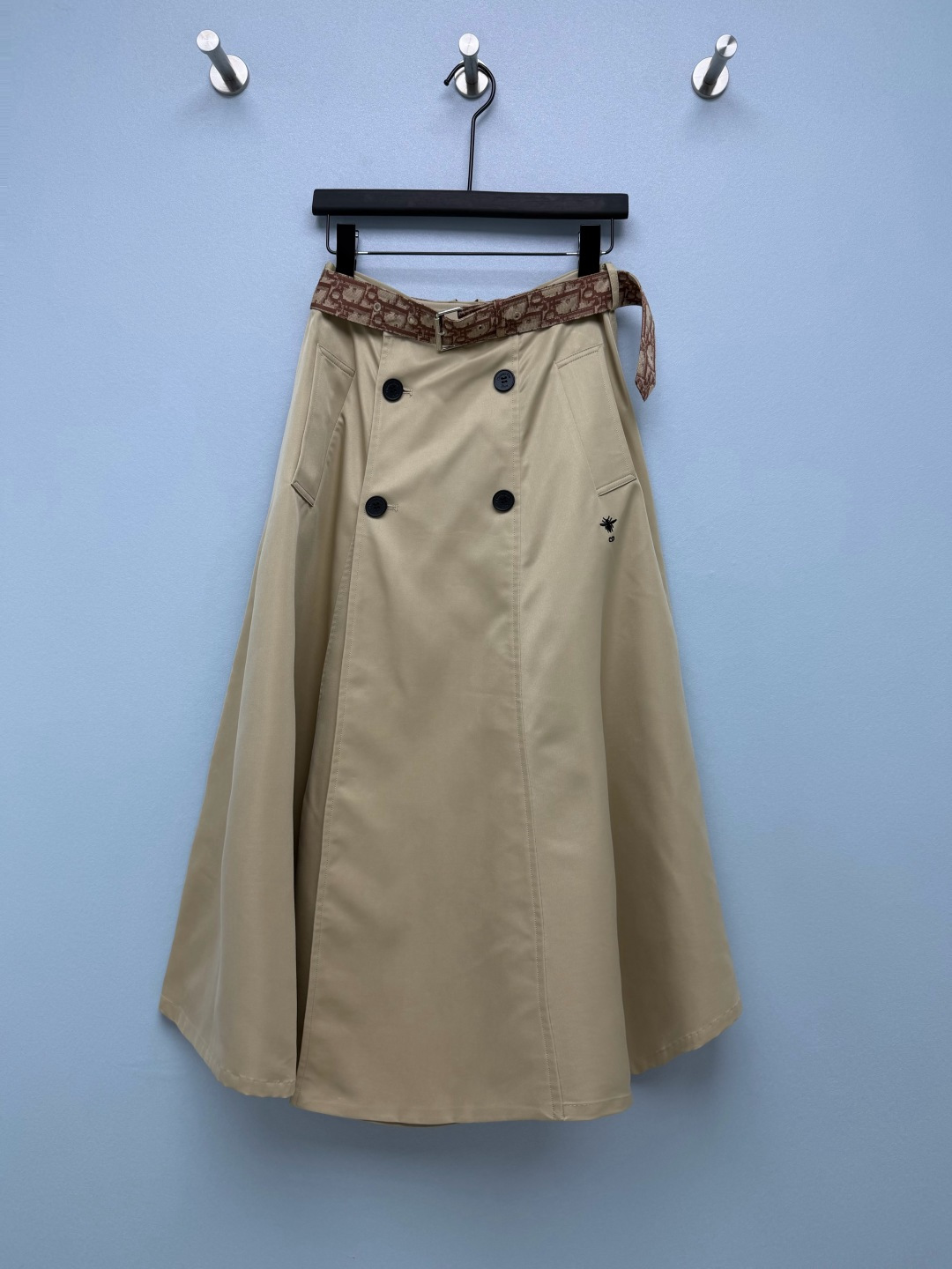 NO:948071,DIO* khaki trench-style double-breasted midi skirt with wide hem  Made of high-density windproof twill cotton fabric, the texture is stiff and stylish, has excellent drape, is not easy to collapse, is breathable and skin-friendly, and is suitable for all seasons. It comes with the same series of Oblique dark pattern jacquard belts, and the metal pin buckle can freely adjust the waist. The belt can be separately detached and matched with other bottoms to increase the layering of the outfit. Double rows of black round buttons on the front simulate the structure of a classic windbreaker, making it visually slimmer.  The fake placket design does not affect walking activities; the right side of the skirt is embellished with a mini bee embroidery logo, which is low-key and luxurious. Symmetrical square patch pockets on both sides restore the details of windbreaker workwear, which have both decorative and practical storage functions. The pockets are neatly and firmly routed. The wide and loose structure makes the skirt stretch and elegant when walking. The split routing strengthens the three-dimensional silhouette and will not cling to the legs and make you look bloated. A-line skirt for pear-shaped figures.  Monochrome size 3 SML, Dior-clothing, dior, dior, skirts,19860909DIO* 卡其风衣式双排扣大摆中长半裙 选用高密防风斜纹棉质面料,肌理挺括有型,垂坠感优异,不易软塌,透气亲肤,四季适配.自带同系列Oblique暗纹提花腰带,金属针扣可自由调节腰围,腰带可单独拆卸搭配其他下装,增加穿搭层次感.正面双排黑色圆形纽扣,模拟经典风衣结构,视觉显瘦,假门襟设计不影响行走活动；裙身右侧点缀迷你蜜蜂刺绣标识,低调轻奢.两侧对称方形贴袋,还原风衣工装细节,兼具装饰与实用收纳功能,口袋走线工整牢固.阔幅散摆结构,走动时裙摆舒展飘逸,分割走线强化立体廓形,不会贴腿显臃肿.梨形身材本命A字大摆裙 单色3码 SML,迪奥-服装,dior,dior,skirts,,Women's clothing