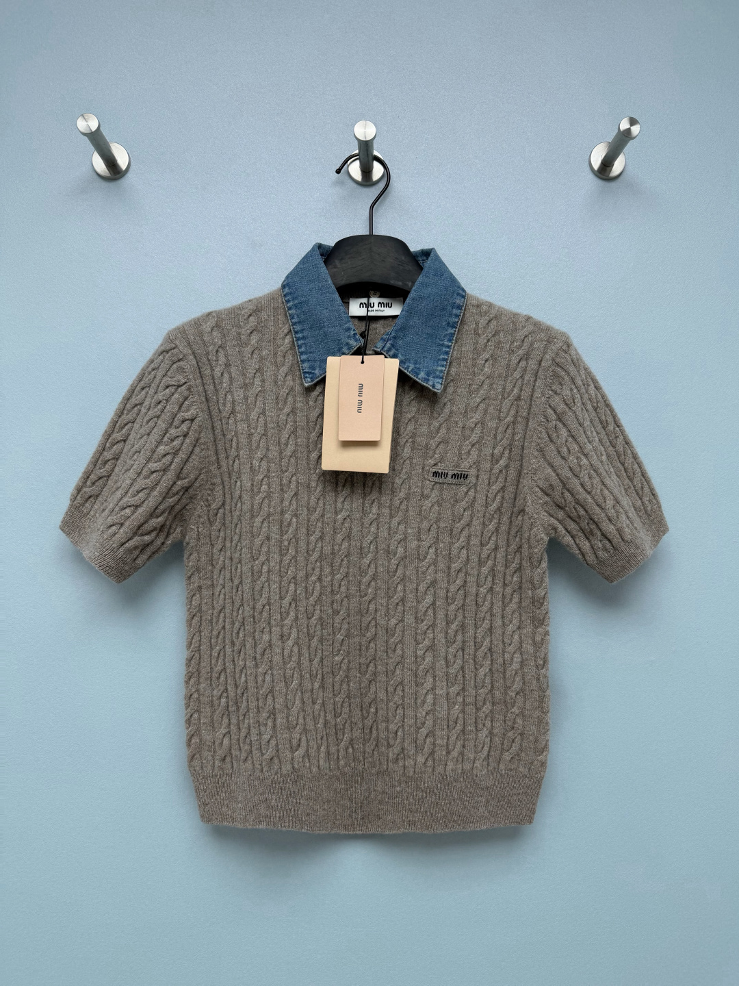 NO:950041,Miu* denim lapel twist short-sleeved sweater  The main body is made of a high proportion of wool and cashmere blended fabric, with a three-dimensional twisted twist weave, which is soft and skin-friendly without being stuck on the body. It has a soft matte matte texture, breathable and warm. The washed denim spliced knitted body has a retro American college style, which neutralizes the gentleness of knitting and balances sweetness and coolness. The handmade woven texture is visually rich and retro.  It has an old-money atmosphere, and its texture is elastic and tolerant of the body shape. The short waisted version is perfect for small people, and the ribbed hem is stuck at the waistline, elongating the proportions of the body. The short sleeves on the shoulders hide the fat. The embroidered logo on the left chest is low-key and not exaggerated. It is low-key and refined, and the brand recognition is full. This short-sleeved knitted retro college feel is full with one click.  Single color code 3 SML, Miumiu-clothing, miumiu, T-shirt,19860909Miu*牛仔翻领麻花短袖针织衫 主体采用高比例羊毛羊绒混纺面料,立体绞花麻花织法,软糯亲肤不扎身,自带柔和哑光雾面质感,透气兼具保暖.水洗丹宁拼接针织衣身,复古美式学院风,中和针织的温柔,甜酷平衡.手工感编织肌理,视觉丰富有复古老钱氛围,肌理自带弹性包容身形.短款收腰版型太懂小个子,罗纹下摆卡在腰线,拉长身材比例,正肩短袖藏住拜拜肉.左胸小织唛刺绣logo低调不浮夸,低调精致,品牌辨识度拉满.这件短袖针织复古学院感一键拉满 单色3码 SML,缪缪-服装,miumiu,T-shirt,,Women's clothing