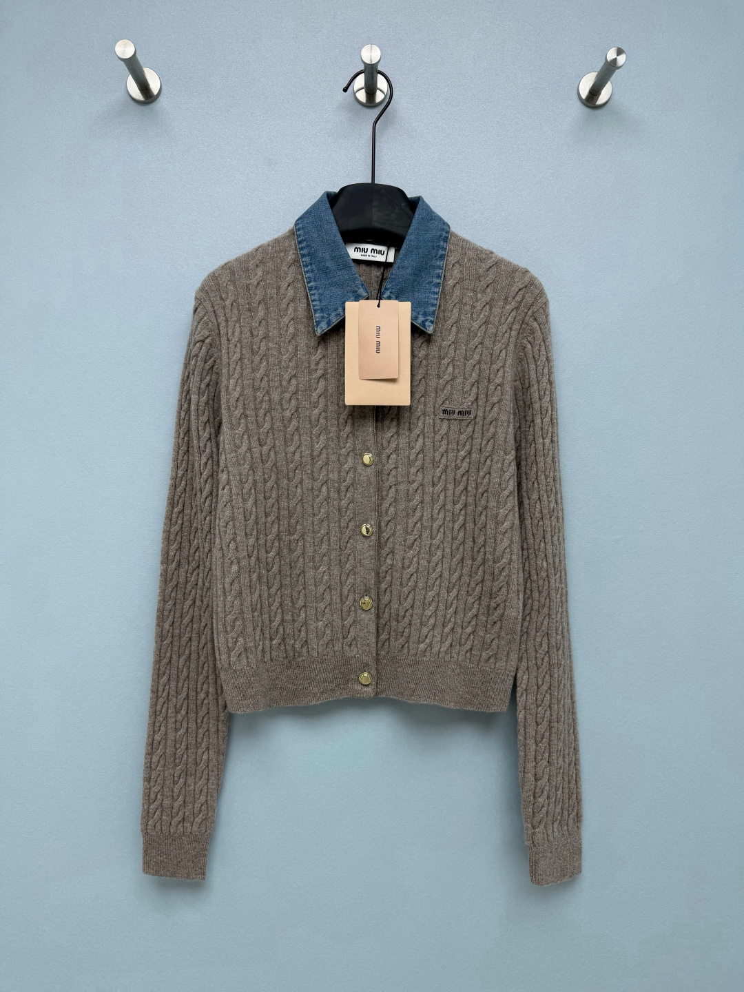 NO:950053,Miu* denim lapel twist long-sleeved knitted cardigan  The main body is made of high-count wool and cashmere blended knitting, with three-dimensional twist knitting all over, which is soft and delicate without any skin-stringing feeling. It has a matte texture and is breathable and constant temperature. The short waisted version is perfect for small people, and the ribbed hem is stuck at the waistline. It can be worn casually with high-waisted bottoms to directly lengthen the legs.  ; Fitted long sleeves + brass gold button placket, full of light and luxurious details. The small woven mark on the left chest is low-key embellishment, the denim collar is retro blue and the softness of the knitting is suitable for both sweet girls and mature commuters. A shirt with its own layering effect, no additional matching is needed, good news for lazy people  Single color code 3 SML, Miumiu-clothing, miumiu, shirts,19860909Miu*牛仔翻领麻花长袖针织开衫 主体采用高支羊毛羊绒混纺针织,通体立体麻花绞花织法,软糯细腻无扎肤感,雾面哑光质感,透气恒温.短款收腰版型太懂小个子,罗纹下摆卡在腰线,随便搭高腰下装直接拉长腿型；合身长袖+黄铜金扣门襟,轻奢细节满满.左胸小织唛低调点缀,牛仔领复古蓝调中和针织的软甜,甜妹、轻熟通勤都能驾驭.一件自带衬衫叠穿效果,不用额外搭配,懒人穿搭福音 单色3码 SML,缪缪-服装,miumiu,shirts,,Women's clothing