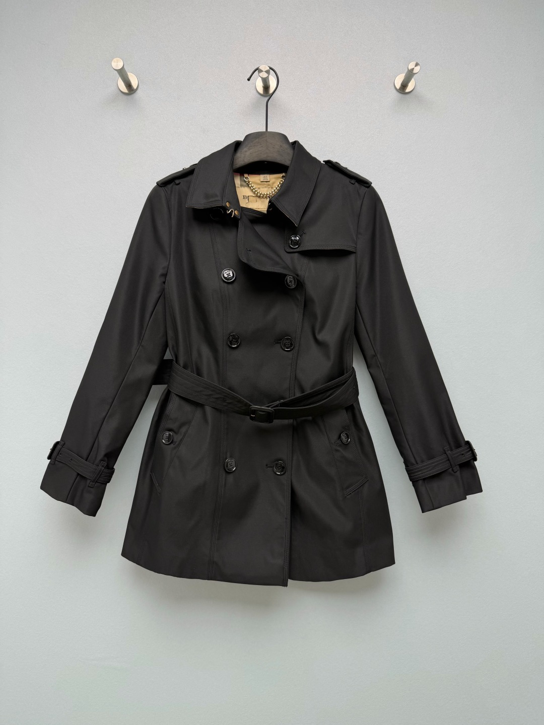 NO:950466,Bur* Sandrine Short Chelsea Fit Women's Trench Coat  High-density cotton gabardine waterproof fabric is windproof and rainproof. The fabric surface is crisp and stylish, and the surface is matte and has a high-end texture. The lapel epaulettes, back windshield, collar buckle, and cuff adjustment tabs completely inherit the design elements of the classic trench coat. The interior is lined with classic Vintage retro plaid, which is highly recognizable for the brand. The collar is equipped with a metal hanging chain, which is an authentic classic detail. Black  Colored resin carved buttons, double rows of symmetrical placket, welt pockets on both sides, taking into account both practicality and workwear aesthetics. The belt is detachable and can be worn loosely and casually, or you can tighten the waist to create a slim look. It can be worn in two clothes. Available in multiple colors: classic khaki, pure black, navy blue, and nude pink, covering a variety of styles including commuting, gentleness, and coolness. The classic Chelsea short version, the length is just right at the crotch, and will not weigh you down at all!  4 colors and 5 codes SMLXLXXL, Burberry-clothing, burberry,19860909Bur*桑德琳短款切尔西版型女士风衣 高密度棉质嘎巴甸防水面料,具备防风防雨属性,布面挺括有型,表面哑光高级质感.翻领肩章、背部防风挡片、领口束带扣、袖口调节袢,完整传承经典战壕风衣设计元素.内里经典Vintage复古格纹内衬,品牌辨识度极强,领口配备金属挂链,是正品经典细节配置.黑色树脂雕花纽扣,双排对称门襟,两侧嵌线口袋,兼顾实用与工装美学.腰带可拆卸,可宽松休闲穿,也可收腰打造修身造型,一衣两穿.多色可选经典卡其、纯黑、藏青、裸粉,覆盖通勤、温柔、酷飒多种穿搭风格.经典切尔西短款版型,长度刚好到胯部,完全不会拖沓压个子！ 4色5码 SMLXLXXL,博柏利-服装,burberry,,Women's clothing