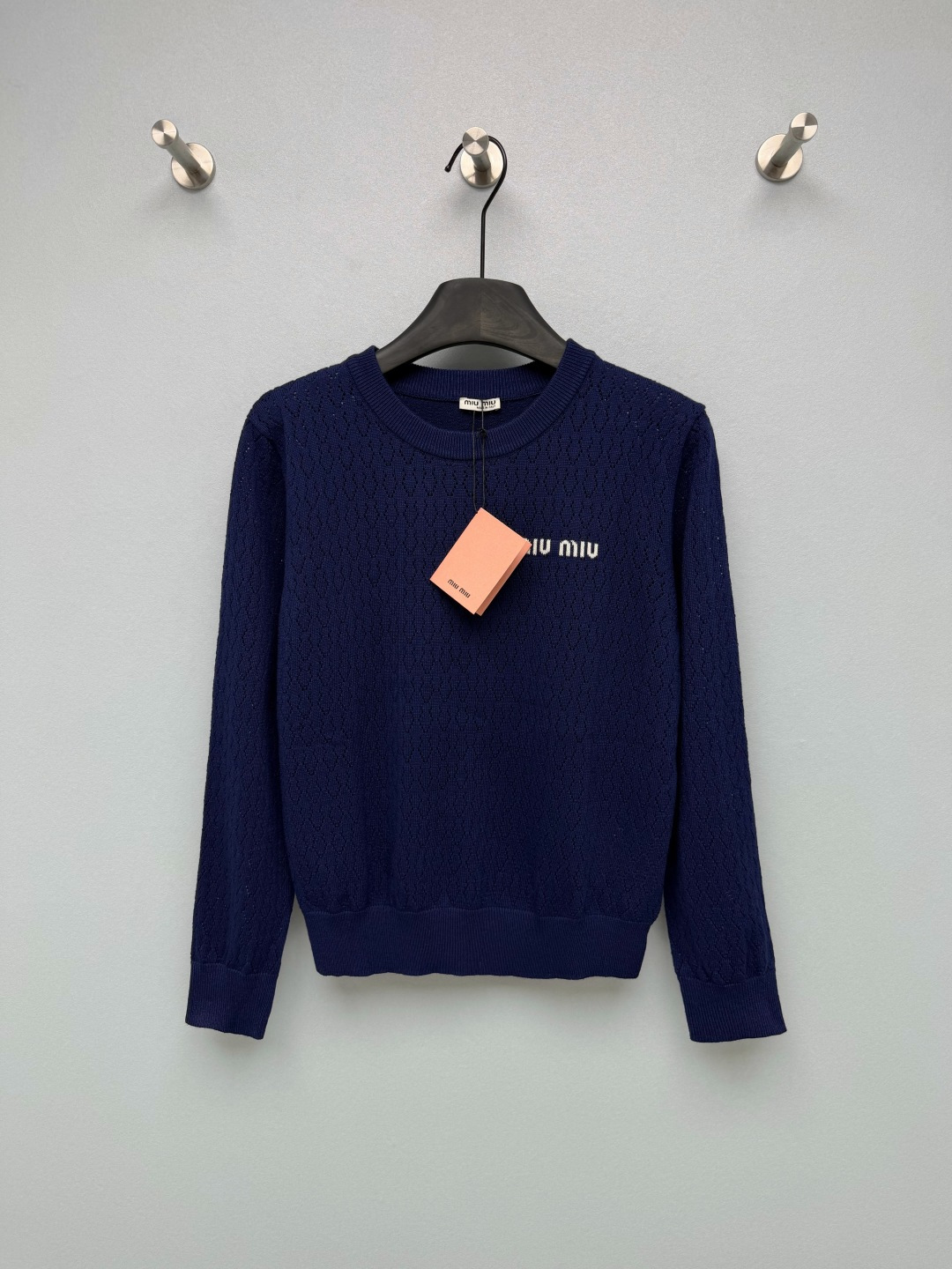 NO:951165,Miu* Hollow round neck knitted long-sleeved top is made of fine combed knitted yarn, and the whole body is made of diamond-shaped hollow mesh. It is breathable and not sweaty, perfect for spring and summer. 'miu' is embroidered horizontally on the left chest  miu', with neat and compact fonts, contrasting embroidery (white fonts for the navy blue version, dark fonts for the off-white version), low-key and eye-catching, with just the right sense of brand atmosphere. The style is a neat short round neck with ribbed edges, which will not cause looseness and deformation. The upper body is just stuck at the waistline, making the legs look longer!  The two colors are directly entangled with the navy retro college style, and the off-white pure Korean style. The two styles are completely different, you can buy them as you like. Two-color 3-code SML, Miu Miu-clothing, miumiu,19860909Miu*镂空圆领针织长袖上衣 采用细支精梳针织纱线,全身菱形镂空网眼织法,透气不闷汗,完美适配春夏季节.左胸口横向字母刺绣「miu miu」,字体工整小巧,撞色刺绣（藏青款白色字、米白款深色字）,低调醒目,品牌氛围感恰到好处.版型是利落短款圆领,罗纹收边,不会松垮变形,上身刚好卡在腰线位置,显腿长一绝！两个配色直接纠结住藏青复古学院风,米白清纯韩系风,两款风格完全不一样,可以随心入手. 双色3码 SML,缪缪-服装,miumiu,,Women's clothing