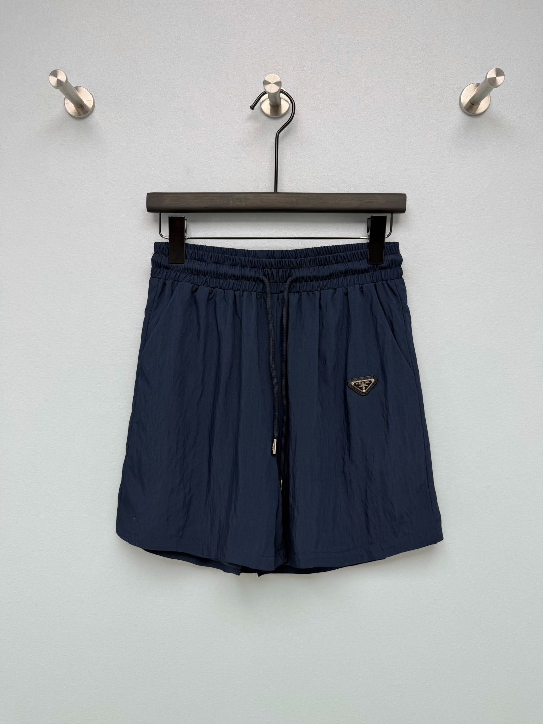 NO:951188,Pra* spring and summer casual quick-drying sports shorts are made of quick-drying nylon fabric, which is light, breathable, dry, waterproof and splash-proof. Sweat evaporates quickly and does not stick to the body. It is light and has no weight-bearing feeling. Elastic waist + metal drawstring, you can adjust the fat or thin at will. The loose five-quarter wide-leg version covers all the thigh flesh, making you look slimmer!  The classic triangular metal logo on the side is simple and low-key, not exaggerated, and has a light and luxurious texture. The pockets on both sides can carry small things with you, perfect for practicality. Two classic colors, navy blue and pure white, directly enhance the atmosphere. Two-color 3-code SML, Prada-clothing, prada, prada, shorts,19860909Pra*春夏休闲速干运动短裤 采用速干锦纶面料,轻薄透气、干爽防水防泼溅,出汗快速蒸发不粘身,轻盈无负重感.松紧腰+金属抽绳,肥瘦随便调节,宽松五分阔腿版型,大腿肉肉全部遮住,显瘦一绝！侧边经典三角金属标,简约低调,不会浮夸,轻奢质感拿捏到位,两侧口袋还能随身放小东西,实用性满分.藏青、纯白两个经典色系,氛围感直接拉满. 双色3码 SML,普拉达-服装,prada,prada,shorts,,Women's clothing