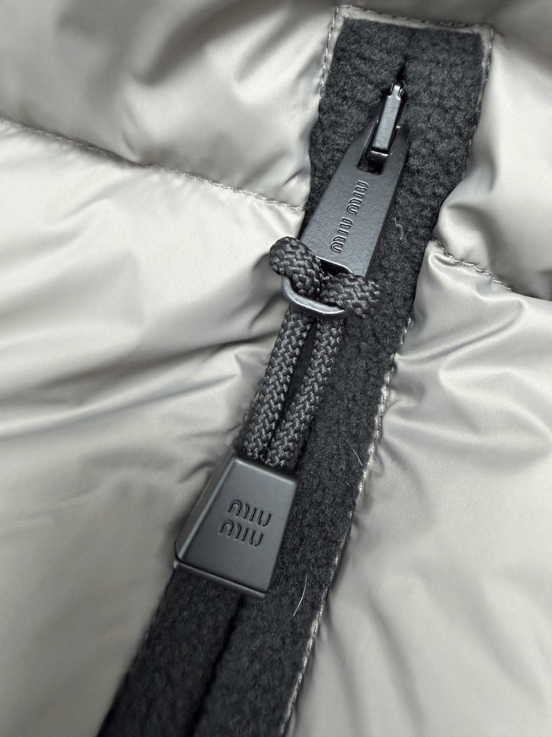 🔥🔥Miu*新款短款连帽鹅绒羽绒服，面料采用耐磨防风的再生聚酰胺材质，填充90%高含量白鹅绒，保暖力出众。低饱和灰调外部