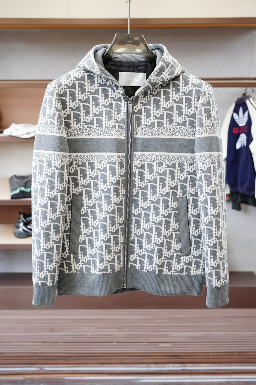 NO:573578,Dior-2025SS early autumn new products  Dark pattern jacquard hooded jacket. Customer-provided hardware decorative accessories. The fabric is made of double-layer polyester fiber composite fabric, which refers to a fabric compounded by a special process. This fabric combines the comfort and breathability of cotton. Only after compounding can the density and texture of the fabric be restored, silky and elastic. The jacquard technology is used in weaving.  In the process, the weaving technology forms a pattern through the interweaving of warp and weft lines. All-over jacquard printing means that the entire fabric is covered with fine patterns and Monogram printing logos. This process makes the fabric more visually rich and three-dimensional, and also increases the uniqueness and recognition of the product.  ……………………………………………………………… SizeM-X XXL,,,dior,jackets & coats,hats,alexander wang19860909迪奥-2025SS早秋新品 暗纹提花连帽夹克.客供五金装饰辅料,面料采用了双层聚酯纤维复合面料指的是特殊工艺复合而成的一种面料.这种面料结合棉舒适性和透气性,复合后才能还原面料的密度质感,丝滑有弹力,提花工艺在织造过程中通过经纬线的交织形成图案的织造技术.满印提花则意味着整个面料上都布满了精细的图案,Monogram印花标志,这种工艺使得面料在视觉上更加丰富和立体,同时也增加了产品的独特性和辨识度. …………………………………………………… SizeM-X XXL,,,dior,jackets & coats,hats,alexander wang,Men's clothing