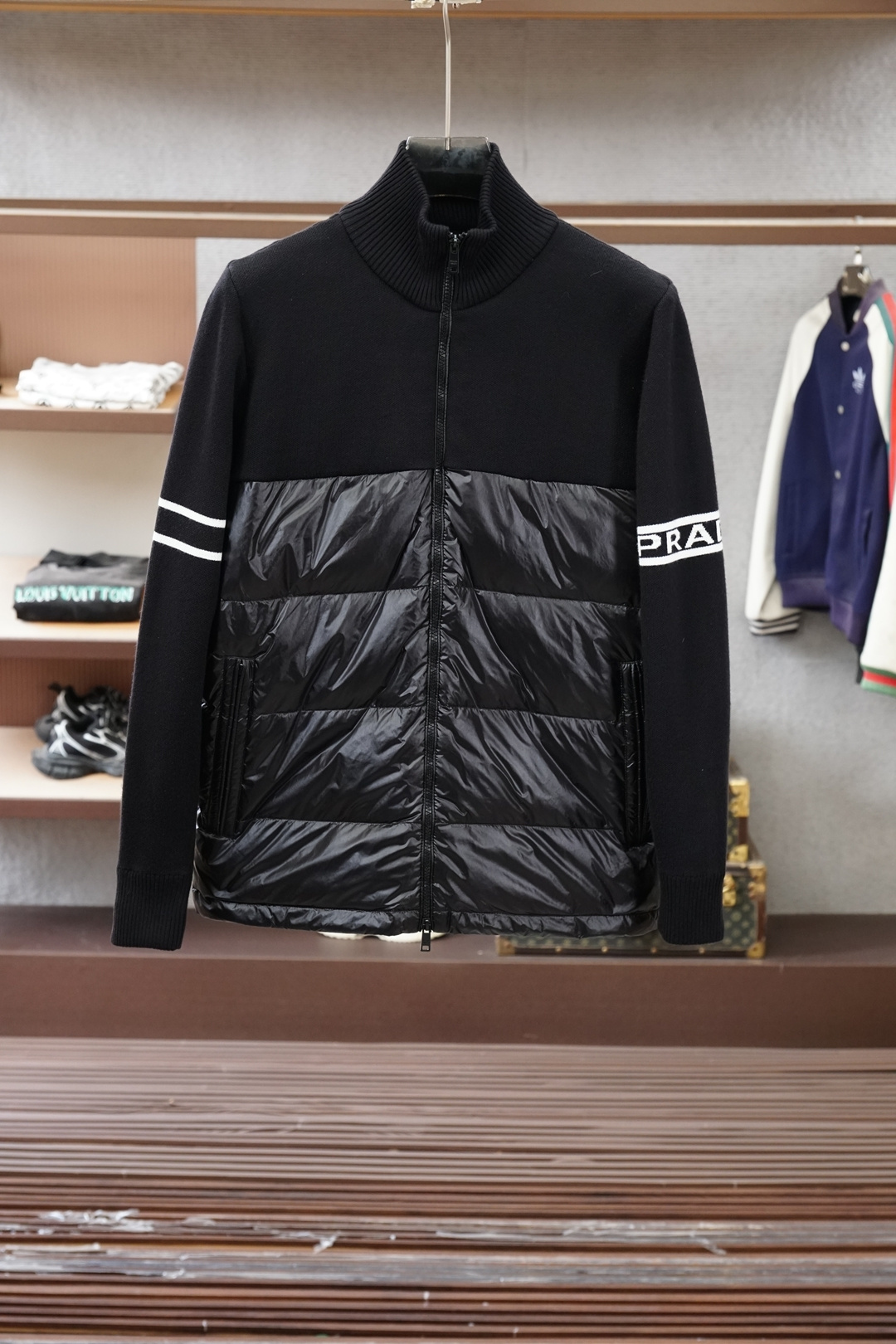 NO:625065,Prada/2025 New Products for Autumn and Winter｜Stand Collar Down Jacket｜Shows fashionable style. It does not follow the conventional design sense. The main body is made of imported fabric blends, environmentally friendly printing and dyeing, and the color is stronger and glossy. The front and rear bodies are filled with large horizontal stripes and filled with 9010 white duck down. It is full and three-dimensional, meeting the needs of warm travel in autumn and winter.  The classic slightly wide cut and stand-up collar design create fashionable and high-end visual lines. The detailed three-dimensional triangle logo and zipper pockets make it easy to mix and match whether it is street style or fashion, showing a casual yet sophisticated dressing attitude. Color Black Size M-3XL, prada, down jacket, alexander wang19860909普拉达/2025 秋冬季新品｜立领羽绒服｜展现时尚风格  不据常规的设计感,大身采用进口面料混纺,环保印染更牢固色泽光感高级.前后身大幅横纹充绒工艺,9010白鸭绒填充,饱满立体,满足秋冬季保暖出行需求.  经典微阔裁剪,立领设计打造流行高级视觉线条.细节立体三角徽标,拉链口袋,无论是街头风格还是时装混搭,皆游刃有余,展现随性却不失精致的穿搭态度. 颜色黑色 尺码M-3XL,,prada,down jacket,alexander wang,Men's clothing