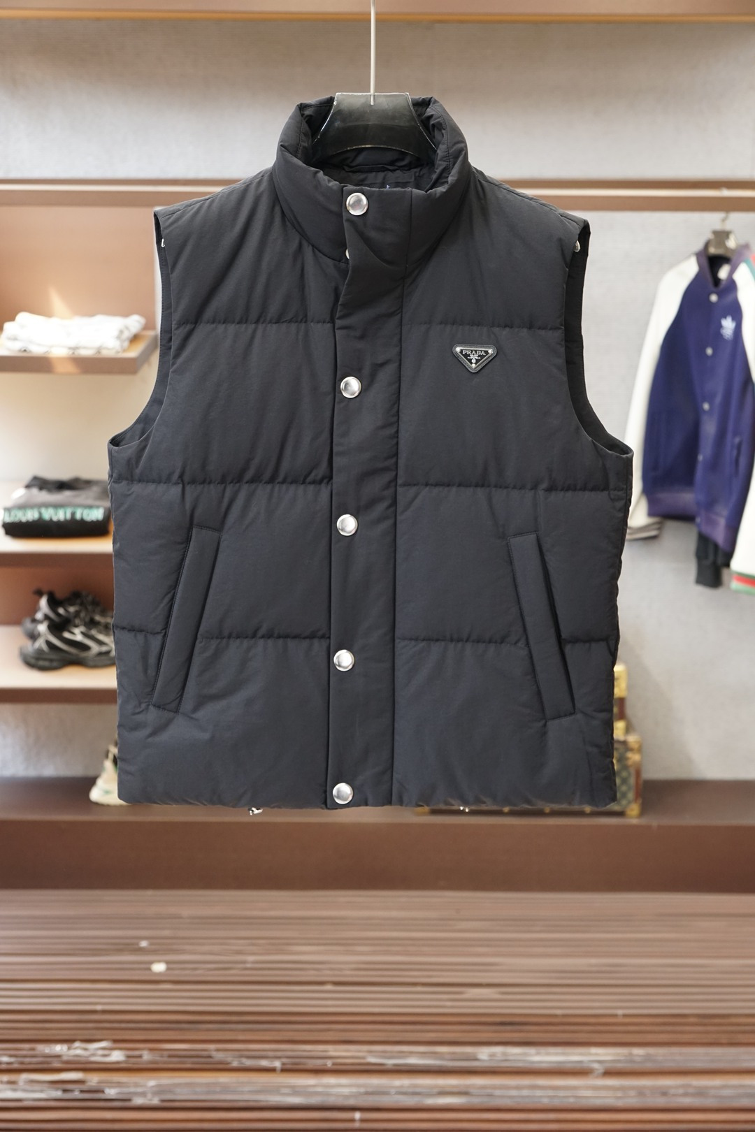 NO:652433,Prada/Black Label Down Vest is a 'texture cheat' for layering in autumn and winter] The stand-up collar + horizontal stripe quilting welds 'light warmth' and 'sleekness' on the body. The triangle logo on the chest is a low-key code, and the metal buckle makes the whole black look more cold. The inner sweatshirt is relaxed for the street, and the layered suit is decent for commuting. A 'versatile hard currency' that can be worn from late autumn to cold winter, it is full of high luxury recognition in minimalism.  M-3XL,,,prada,prada,hoodie,sweatshirts,down jacket,business suit,alexander wang19860909Prada普拉达/黑标羽绒马甲秋冬叠穿的“质感作弊器”】 立领+横条绗缝,把“轻暖”和“利落”焊在身上 胸口三角标是低调暗号,金属扣衬得全黑更有冷冽质感 内搭卫衣是街头松弛,叠穿西装是通勤体面 一件能从深秋穿到寒冬的“百搭硬通货”,极简里全是高奢辨识度 M-3XL,,,prada,prada,hoodie,sweatshirts,down jacket,business suit,alexander wang,Men's clothing