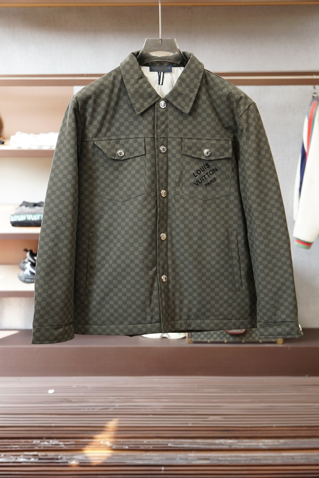 NO:681972,LV checkerboard down jacket is the ceiling of winter luxury. LV's checkerboard down jacket directly combines trend and texture. The classic Damier checkerboard pattern covers the body. The black and gray tones are high-end and eye-catching, and the military green version has its own retro accent, which will fall into your eyes at a glance. The shirt-style lapel design is neat and versatile. It is casual and trendy when worn alone, and layered with coats for a layered look.  The down jacket is light yet warm, without the bloated feeling of traditional down jackets. The metal buttons and embroidered logo details are full of details, showing the luxury brand craftsmanship. The loose fit is not flattering on the figure. Whether it is worn with jeans or casual trousers, it can easily achieve the high-street luxury trend!  M-3XL, maintenance tips: avoid vigorous scrubbing of checkerboard fabrics. Professional dry cleaning is recommended to protect the pattern, louis vuitton, jeans, shirts, down jacket,19860909LV棋盘格羽绒服,冬日奢潮天花板 LV这款棋盘格羽绒服直接把潮流与质感拉满 经典的Damier棋盘格纹铺满衣身_黑灰调高级又耐看,军绿款更是自带复古腔调,一眼就沦陷 衬衫式翻领设计利落又百搭,单穿是休闲潮范,叠搭大衣又能穿出层次感 充绒轻盈却保暖,完全没有传统羽绒服的臃肿感,金属纽扣和刺绣logo细节拉满,尽显奢牌工艺 版型宽松不挑身材,不管是配牛仔裤还是休闲西裤,都能轻松拿捏高街奢潮感！M-3XL, 养护小知识棋盘格面料避免大力搓洗,建议专业干洗保护图案,,louis vuitton,jeans,shirts,down jacket,,Men's clothing