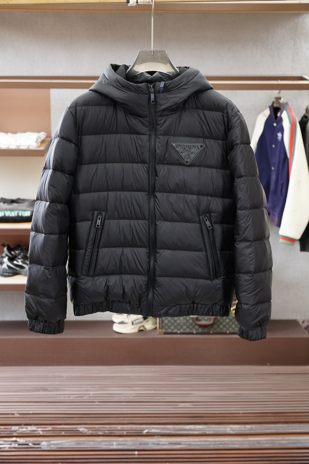 NO:690960,Prada hooded down jacket | The lazy and high-end feel of winter luxury products Who knows the gold content of this hooded down jacket from Prada!  I bought their knitted patchwork model before, and this time I closed my eyes and jumped at it when I saw the hooded model. I was not disappointed ~ The overall design is filled with lightweight quilted down, and the upper body is fluffy but not bloated at all. The hood design is detachable (it is hooded in the picture). When it is cold, the hood can be pulled up to maximize the warmth. The triangle logo embossed on the chest is low-key and textured. It is not as ostentatious as the metal logo, but it cannot hide Prada’s luxury gene.  Pure black color + drawstring hem design, you can adjust the fit at will. Pair it with sweatpants for a lazy and casual style. With jeans, you can wear it in an urban man's style. You can just put it on when you go out every day. Lazy people will be ecstatic when wearing it!  The details are also very attentive, the zipper pockets are designed to be non-slip, and the knitted cuffs are also windproof. A down jacket achieves the ultimate in practicality and high-end sense. Prada’s aesthetic has never lost touch~ #Prada #prada #hooded down jacket #winter wear #luxury wear #Men light luxury #lazy wear,, prada, prada, jeans, down jacket, hats,19860909Prada连帽羽绒｜冬日奢品的慵懒高级感谁懂Prada这件连帽羽绒服的含金量啊！ 之前入了他家针织拼接款,这次看到连帽款直接闭眼冲,果然没让我失望～ 整体是轻量化绗缝羽绒填充,上身蓬松但完全不臃肿,连帽设计是可拆卸的（图片里是连帽状态）,冷风天拉上帽子,保暖性直接拉满 胸前压印的三角标低调又有质感,不像金属标那么张扬,却藏不住Prada的奢品基因. 纯黑的配色+抽绳下摆设计,能随意调节版型,搭卫裤是慵懒休闲风,配牛仔裤又能穿出都市型男范,日常出门套上就走,懒人穿搭党狂喜！ 细节也超用心,拉链口袋做了防滑设计,针织收口的袖口还能防风,一件羽绒服把实用性和高级感做到了极致,Prada的审美真的从没掉线～ #Prada #普拉达 #连帽羽绒服 #冬日穿搭 #奢侈品穿搭 #男士轻奢 #懒人穿搭,,prada,prada,jeans,down jacket,hats,,Men's clothing