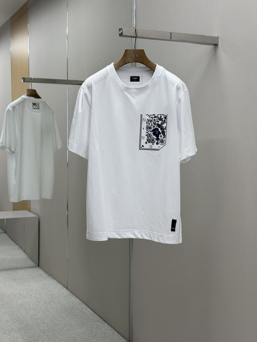 NO:414797,FENDI Coral Printed Short-sleeved T-shirt Fabric Selection: It is made of high-stretched long-length cotton. The warp and weft density can reach 1,000 inches. The cloth surface is tight and flat, and the touch is smooth like silk. The high-density structure enhances the durability of the fabric, is not easy to pill and deform, and has good wrinkle resistance. Cotton fibers are naturally skin-friendly, breathable and hygroscopic, and are soft and non-irritating. Process 1 The coral flower pattern is presented on the fabric through glue printing, with uniform spatula pressure. The chest patch sheet is scratched by the printer for 30 times to ensure that the printing thickness presents a micro three-dimensional convex structure, and the glue is fully penetrated and covered. The back sheet printing is relatively thin after 7 scratches, but it does not hinder its beauty and firmness. Finally, after high-temperature curing, the pigment is firmly combined with the cotton fiber, and the ink-absorbing characteristics of the cotton fiber make the pattern not easily fall off due to friction.  Process 2 The fabric is uniformly humidified by steam, squeezed with a heated roller and an elastic rubber blanket, forcing the fibers to retract, and finally cooling the form through cold air to fix the shape. After treatment, the shrinkage rate is controlled within 3. SIZE: SML XL,,fendi,T-shirt,tees,t-shirt,alexander wang19860909FENDI珊瑚花印花短袖T恤 面料选择 选用高支长绒棉编织而成 ,经纬密度可达1000根英寸,布面紧密平整,触感光滑如丝绸,高密度结构增强了面料的耐用性,不易起球变形,且有良好的抗皱性.棉纤维具有天然的亲肤性,透气性和吸湿性并存,贴身柔软,无刺激. 工艺1 通过胶浆印花在面料上呈现珊瑚花图案,刮刀压力均匀,胸贴袋片经过印花师30次刮印确保印花厚度呈现微立体凸起结构,并使胶浆充分渗透并覆盖.后片印花经过7次刮印相对较薄,但同样不妨碍其美感和牢固度.最后通过高温固化后,颜料与棉纤维结合牢固,棉纤维的吸墨渗透特性使图案不易因摩擦导致脱落. 工艺2 面料经蒸汽均匀加湿,用加热后的辊筒与弹性橡胶毯挤压,迫使纤维回缩,最后通过冷风降温固定形态.经过处理之后将缩水率控制在3以内. SIZE: SML XL,,fendi,T-shirt,tees，t-shirt,alexander wang,Men's clothing