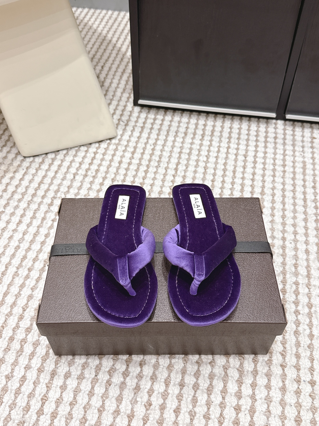 NO:759687,Purchasing agent level ALAI*·26s new spring and summer velvet minimalist design flip flops. The magic of velvet is that the same material has one color when viewed against the light, and another when viewed against the light.  This pair of Alaia flip-flops brings this change to the feet. The 'Y'-shaped structure of the upper naturally cuts out three different light-receiving surfaces under the light - the one above the instep is always the brightest, while the two sides sink into gentle shadows. Those are not signs of wear and tear, but a conspiracy between velvet and light.  The most difficult part of the craftsmanship is the processing of the toe clip. The craftsman needs to use a special thin cone to penetrate the velvet strap into the midsole of the shoe, and then manually fix it with fish thread to ensure that every stitch is hidden deep in the velvet. You can’t see any stitches from the surface, but it is strong enough to accompany you through many summers. When you walk around, the velvet will ripple slightly with the ups and downs of your feet, like the wind blowing through a wheat field. Those are not wrinkles, but light dancing on your instep. Material Corduroy  Outsole Imported from Italy, genuine leather outsole, shoe size 35-39/40, customized, non-returnable, split-toe shoes, alaia, Leather soles19860909代购级 ALAI*·26s 春夏新款 丝绒极简设计夹趾拖 丝绒的神奇在于,同样的材质,顺着光是一种颜色,逆着光又是另一种. 这双Alaia夹趾拖,把这种变幻穿在了脚上.鞋面的“Y”形结构,天然地在光线下切割出三个不同的受光面——脚背上方的那一片永远最亮,两侧则沉入温柔的阴影里.那不是穿旧了的痕迹,是丝绒与光的共谋. 工艺上最难的是夹趾部分的处理.匠人需要用特制的细锥将丝绒带穿入鞋底夹层,再用鱼丝线手工固定,确保每一针都藏在绒毛深处.你从表面看不出任何缝线,但它的牢固足以陪你走过很多个夏天. 当你走动时,丝绒随着脚的起伏泛起细微的波纹,像风吹过麦田.那不是褶皱,是光在你脚背上跳舞. 材质灯芯绒 大底意大利进口真皮大底 鞋码35-39/40定制不退换,分趾鞋,alaia,Leather soles,Women's Shoes