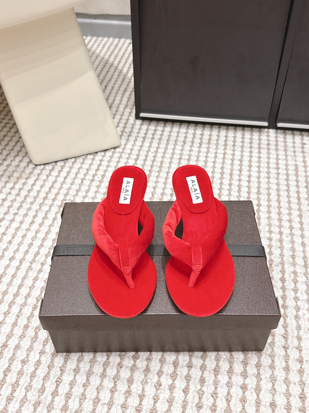 NO:759668,Purchasing agent level ALAI*·26s new spring and summer velvet minimalist design flip flops. The magic of velvet is that the same material has one color when viewed against the light, and another when viewed against the light.  This pair of Alaia flip-flops brings this change to the feet. The 'Y'-shaped structure of the upper naturally cuts out three different light-receiving surfaces under the light - the one above the instep is always the brightest, while the two sides sink into gentle shadows. Those are not signs of wear and tear, but a conspiracy between velvet and light.  The most difficult part of the craftsmanship is the processing of the toe clip. The craftsman needs to use a special thin cone to penetrate the velvet strap into the midsole of the shoe, and then manually fix it with fish thread to ensure that every stitch is hidden deep in the velvet. You can’t see any stitches from the surface, but it is strong enough to accompany you through many summers. When you walk around, the velvet will ripple slightly with the ups and downs of your feet, like the wind blowing through a wheat field. Those are not wrinkles, but light dancing on your instep. Material Corduroy  Heel height 5.5cm. Outsole. Genuine leather outsole imported from Italy. Shoe size 35-39/40. Customized. Non-returnable. Split-toe shoes, alaia, Leather soles.19860909代购级 ALAI*·26s 春夏新款 丝绒极简设计夹趾拖 丝绒的神奇在于,同样的材质,顺着光是一种颜色,逆着光又是另一种. 这双Alaia夹趾拖,把这种变幻穿在了脚上.鞋面的“Y”形结构,天然地在光线下切割出三个不同的受光面——脚背上方的那一片永远最亮,两侧则沉入温柔的阴影里.那不是穿旧了的痕迹,是丝绒与光的共谋. 工艺上最难的是夹趾部分的处理.匠人需要用特制的细锥将丝绒带穿入鞋底夹层,再用鱼丝线手工固定,确保每一针都藏在绒毛深处.你从表面看不出任何缝线,但它的牢固足以陪你走过很多个夏天. 当你走动时,丝绒随着脚的起伏泛起细微的波纹,像风吹过麦田.那不是褶皱,是光在你脚背上跳舞. 材质灯芯绒 跟高5.5cm 大底意大利进口真皮大底 鞋码35-39/40定制不退换,分趾鞋,alaia,Leather soles,Women's Shoes