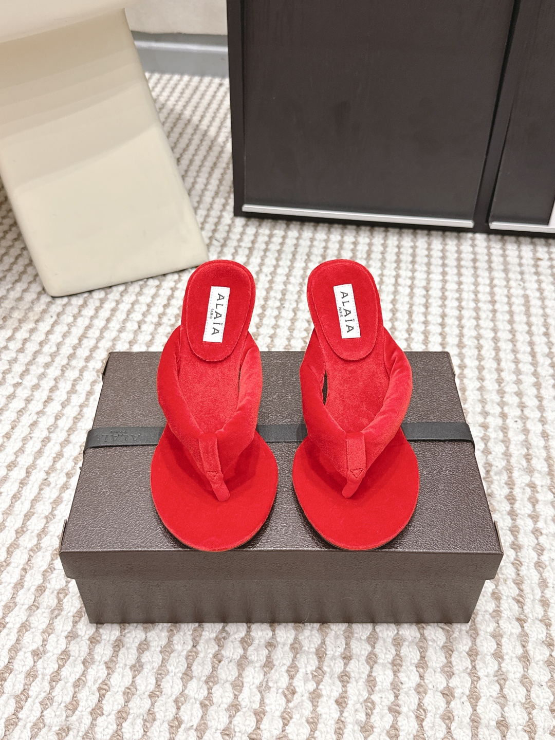 NO:759676,Purchasing agent level ALAI*·26s new spring and summer velvet minimalist design flip flops. The magic of velvet is that the same material has one color when viewed against the light, and another when viewed against the light.  This pair of Alaia flip-flops brings this change to the feet. The 'Y'-shaped structure of the upper naturally cuts out three different light-receiving surfaces under the light - the one above the instep is always the brightest, while the two sides sink into gentle shadows. Those are not signs of wear and tear, but a conspiracy between velvet and light.  The most difficult part of the craftsmanship is the processing of the toe clip. The craftsman needs to use a special thin cone to penetrate the velvet strap into the midsole of the shoe, and then manually fix it with fish thread to ensure that every stitch is hidden deep in the velvet. You can’t see any stitches from the surface, but it is strong enough to accompany you through many summers. When you walk around, the velvet will ripple slightly with the ups and downs of your feet, like the wind blowing through a wheat field. Those are not wrinkles, but light dancing on your instep. Material Corduroy  Heel height 8.5cm. Outsole. Genuine leather outsole imported from Italy. Shoe size 35-39/40. Customized and non-returnable. Split-toe shoes, alaia, Leather soles.19860909代购级 ALAI*·26s 春夏新款 丝绒极简设计夹趾拖 丝绒的神奇在于,同样的材质,顺着光是一种颜色,逆着光又是另一种. 这双Alaia夹趾拖,把这种变幻穿在了脚上.鞋面的“Y”形结构,天然地在光线下切割出三个不同的受光面——脚背上方的那一片永远最亮,两侧则沉入温柔的阴影里.那不是穿旧了的痕迹,是丝绒与光的共谋. 工艺上最难的是夹趾部分的处理.匠人需要用特制的细锥将丝绒带穿入鞋底夹层,再用鱼丝线手工固定,确保每一针都藏在绒毛深处.你从表面看不出任何缝线,但它的牢固足以陪你走过很多个夏天. 当你走动时,丝绒随着脚的起伏泛起细微的波纹,像风吹过麦田.那不是褶皱,是光在你脚背上跳舞. 材质灯芯绒 跟高8.5cm 大底意大利进口真皮大底 鞋码35-39/40定制不退换,分趾鞋,alaia,Leather soles,Women's Shoes