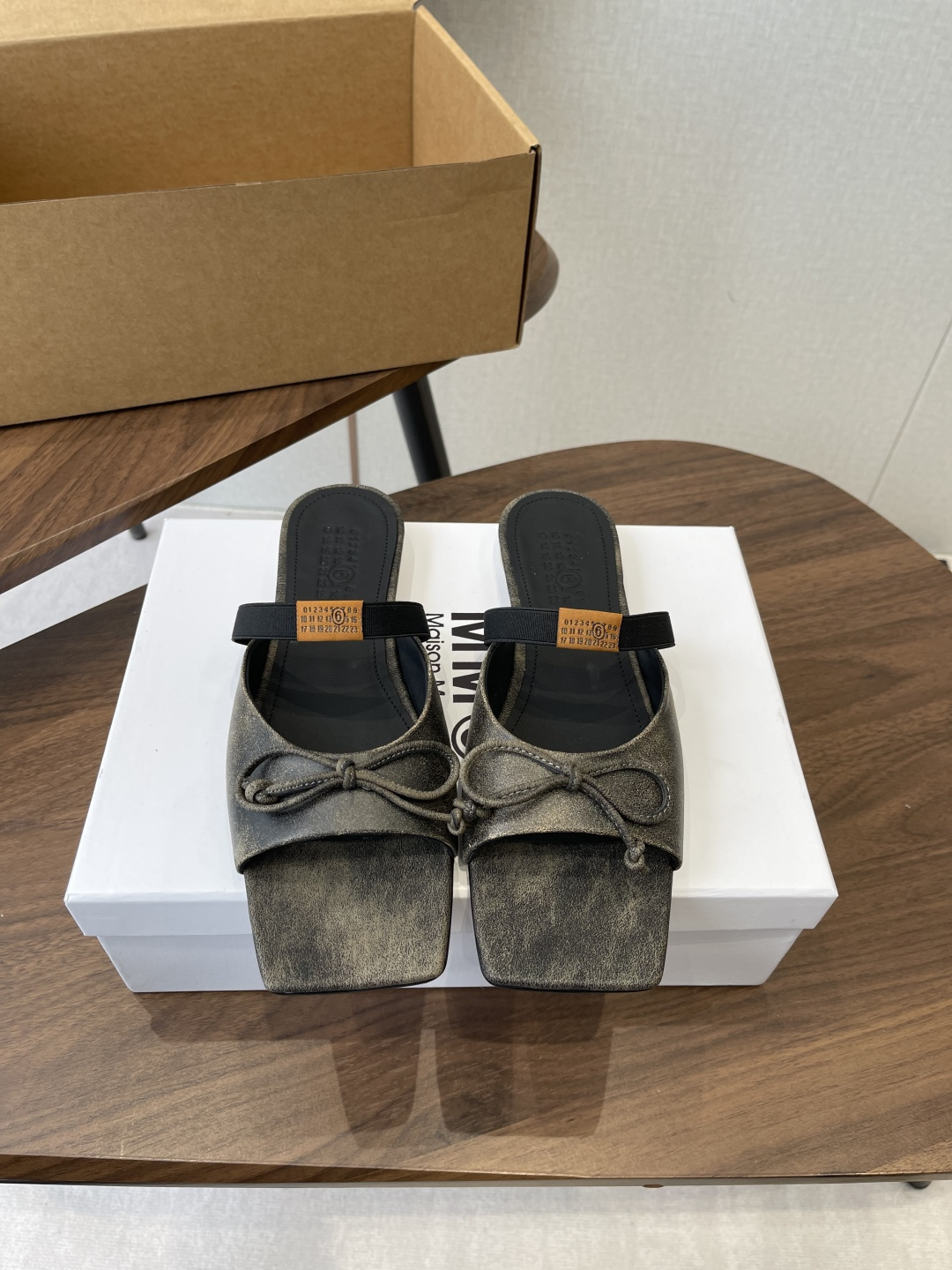 NO:680491,Maison Margiel square toe elastic strap ballet flats and sandals adopt the brand's signature sculptural silhouette that fits the shape of the foot. The upper is soft and smooth, taking into account both fit and design. The square toe + ballet elements are combined with the classic square toe design to create a modern feel. It is paired with the bow decoration on the upper to reconstruct the elegant outline of the ballet shoes. At the same time, it has a mules-back style, which is both casual and refined.  There is the iconic white single-thread stitching on the heel, and the elastic band of the shoe body has the MM6 digital logo, which is the key to brand recognition. The empty mule slip structure simplifies the way of putting on and taking off, combining the softness of ballet shoes with the casualness of mule shoes. The upper is retro burst cowhide, the lining is silk sheepskin, the outsole is genuine leather, and the height is increased by 2.5cm.  margiela,sandals,flats,slippers,cowhide,sheepskin,Leather soles19860909Maison Margiel方头弹力带芭蕾鞋平底鞋凉鞋 采用品牌标志性的贴合脚型的雕塑感轮廓,鞋面柔软且线条流畅,兼顾贴合度与设计感.方头+芭蕾元素融合经典方头设计打造现代感,搭配鞋面蝴蝶结装饰,重构芭蕾鞋的优雅轮廓,同时做穆勒拖的后空款式,兼具休闲与精致. 鞋后跟处有标志性的白色单线缝线,鞋身弹性带带有MM6数字标识,是品牌辨识度的关键.后空的穆勒拖结构,简化穿脱方式,将芭蕾鞋的柔美与穆勒鞋的随性结合. 鞋面复古爆裂牛皮 内里丝绸羊皮里 大底真皮大底 增高2.5cm size :35-41码（40、41码定制不退换）,拖鞋芭蕾舞鞋,masion margiela,sandals,flats,slippers,cowhide,sheepskin,Leather soles,Women's Shoes